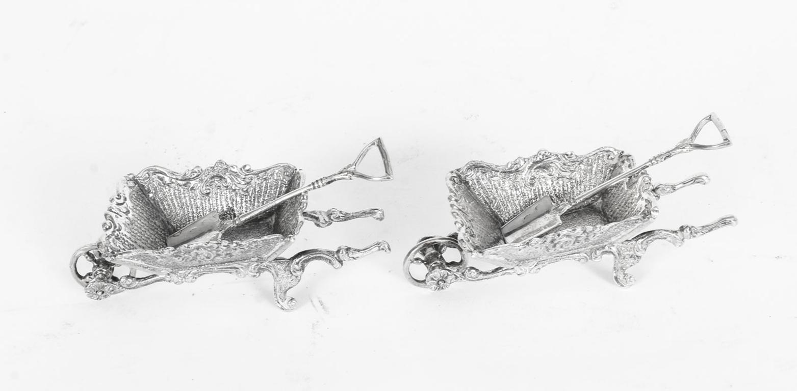 This is a charming pair of antique French silver novelty table salt condiments in the form of garden wheelbarrows, dating from the late 19th century.
 
Each wheel barrow having 'C' scroll Rococo style decoration to the bodies with shaped handles