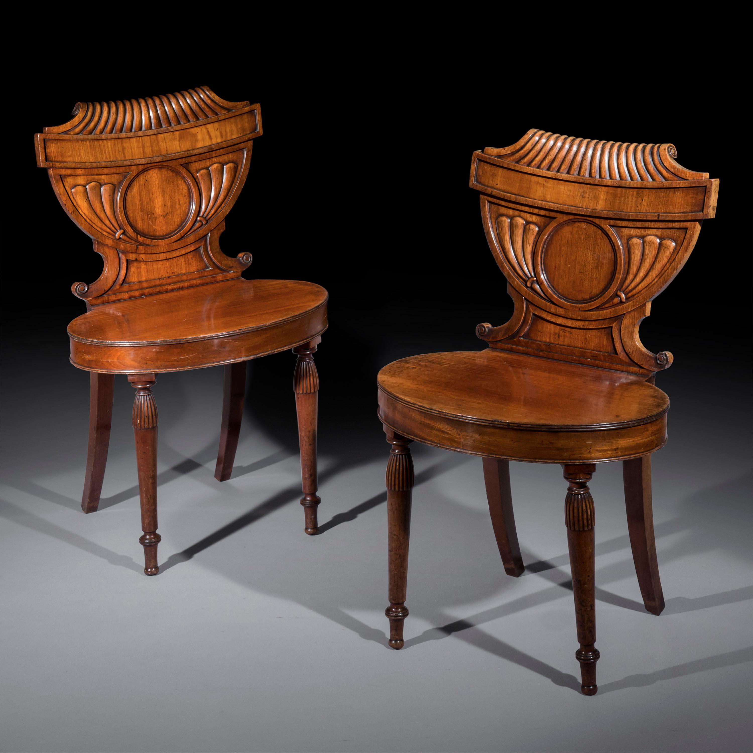 An unusual pair of hall chairs of the late George III - early Regency period, with urn-shaped backs and oval seats
English or Scottish, circa 1800.

Why we like them
These chairs are made to an extremely unusual neoclassical design, possibly for an