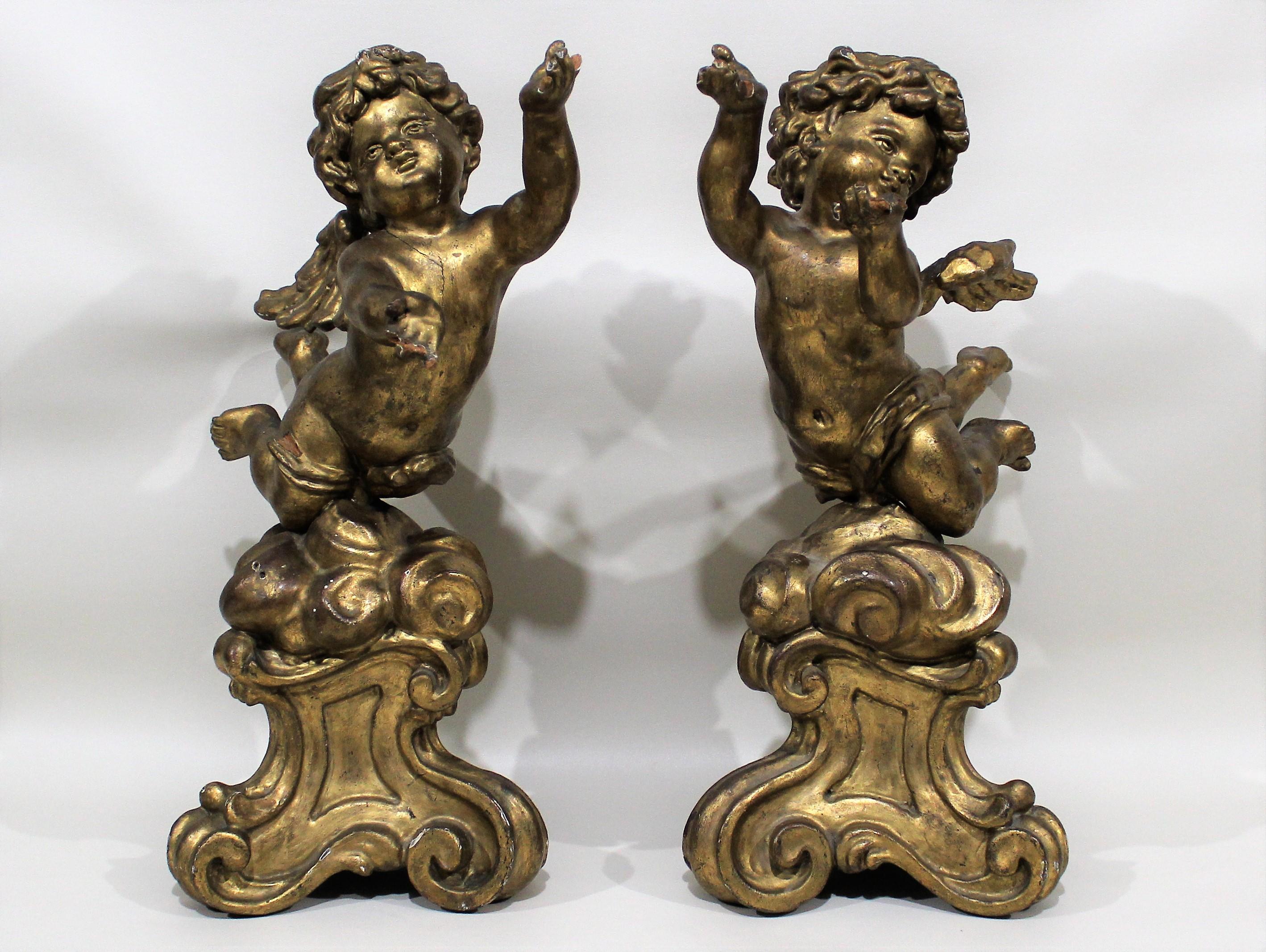 Pair of gilt carved wood putti figures atop decorative tripod bases.