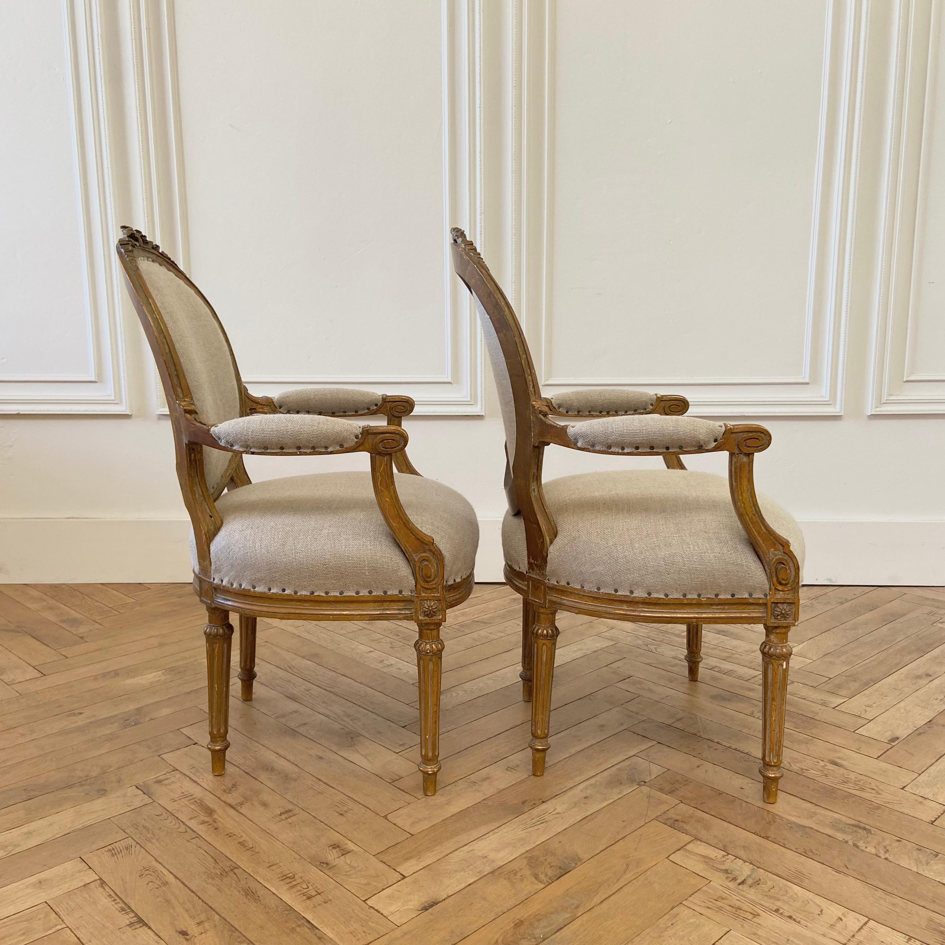 20th Century Antique Pair of Gilt Wood Open Arm Chairs Upholstered in Natural Linen For Sale