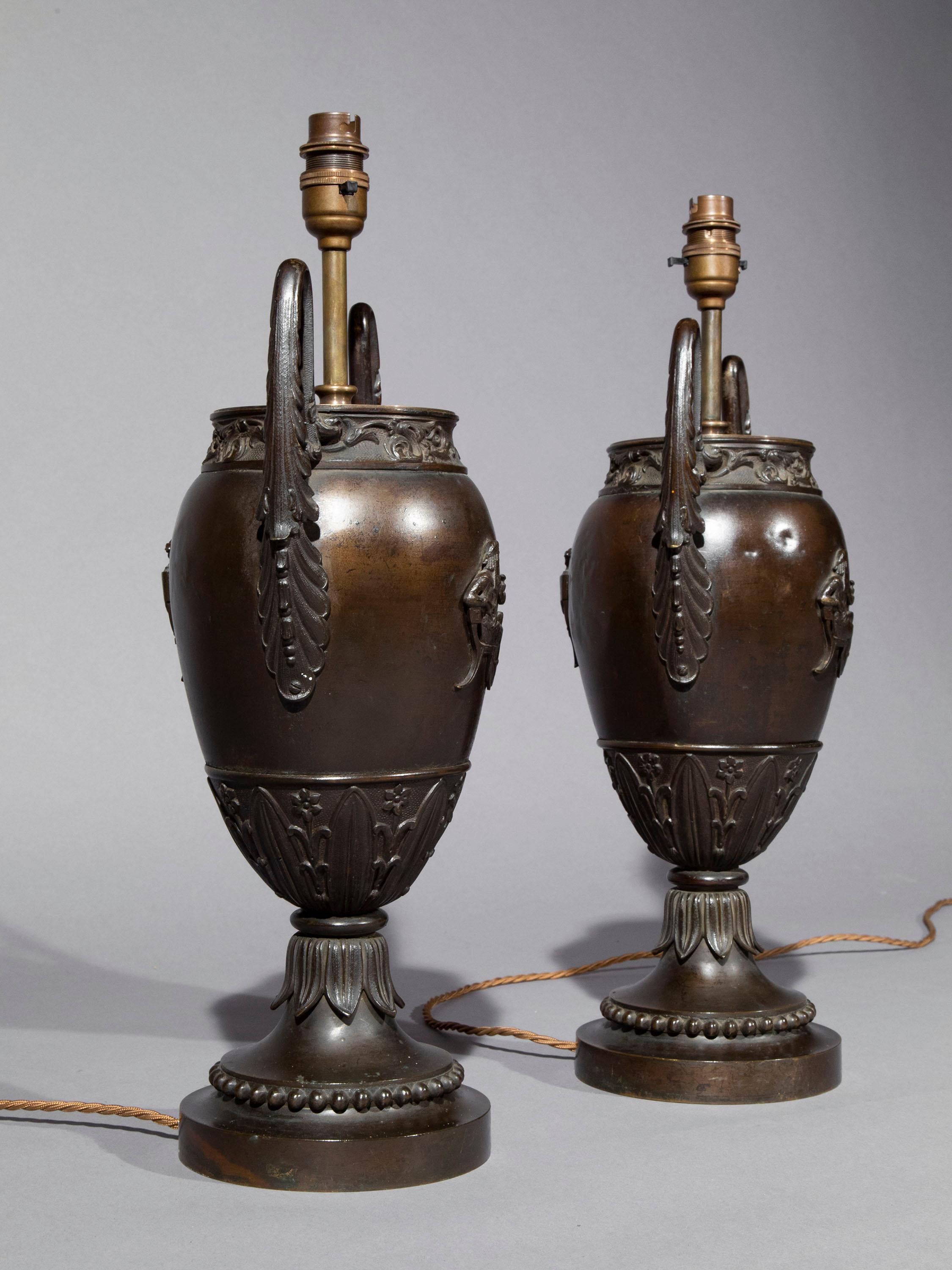 A very decorative pair of fine quality antique patinated urns fitted as table lamps,  
England, early 19th century.

Why we like them
These wonderfully chic lamps are decorated with very fine applied figures of classical Greek youths seated on