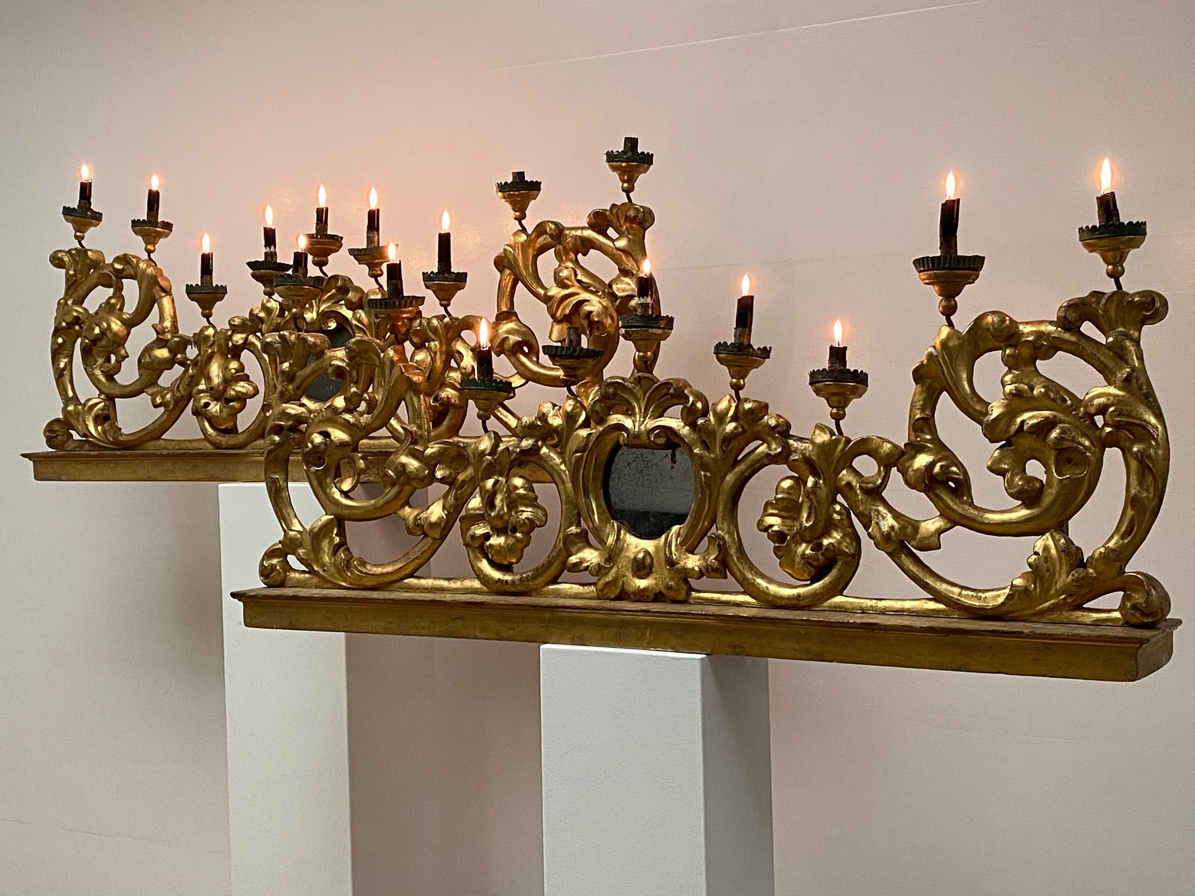 Exceptionnelle paire de lustres italiens anciens en bois patiné et doré, provenant probablement d'une église italienne en Toscane,
les lustres ont un design très raffiné et il y a un petit miroir au milieu, ainsi que 9 bras pour mettre vos bougies,