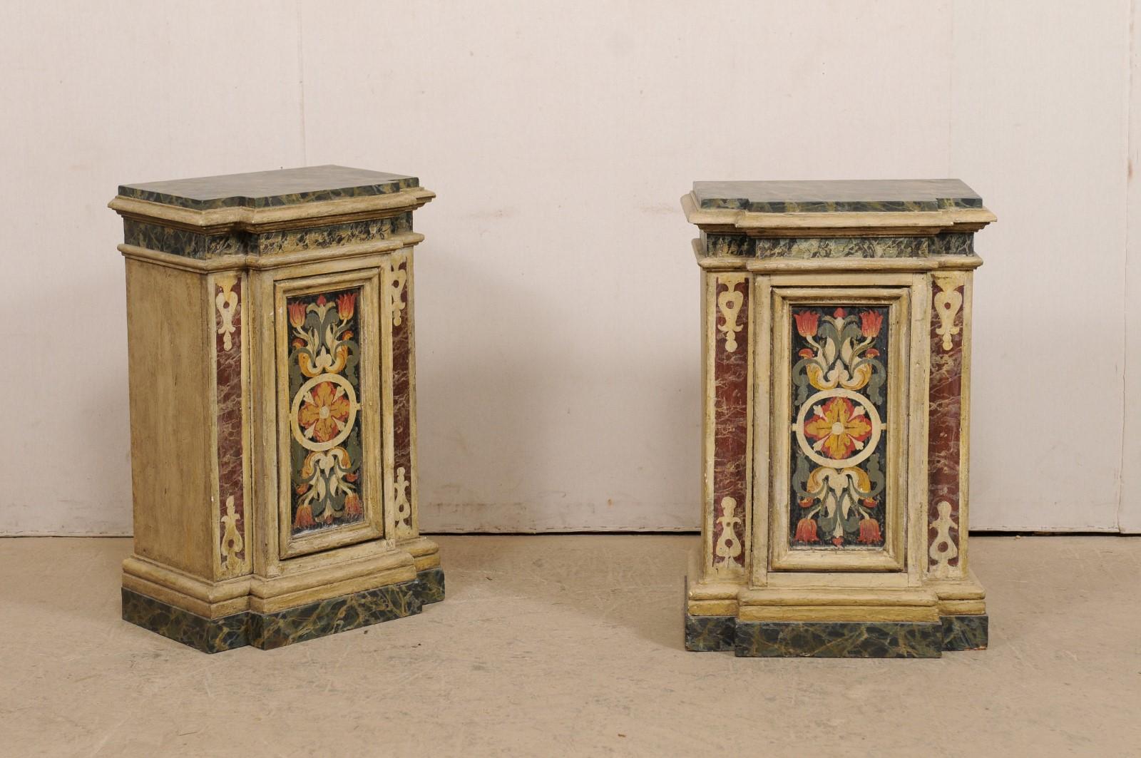 An Italian pair of wooden pedestals, with their original artisan paint, from the turn of the 18th and 19th century. This antique pair of wood columns from Italy each have break-front shaped bodies which feature a single recessed panel at each front
