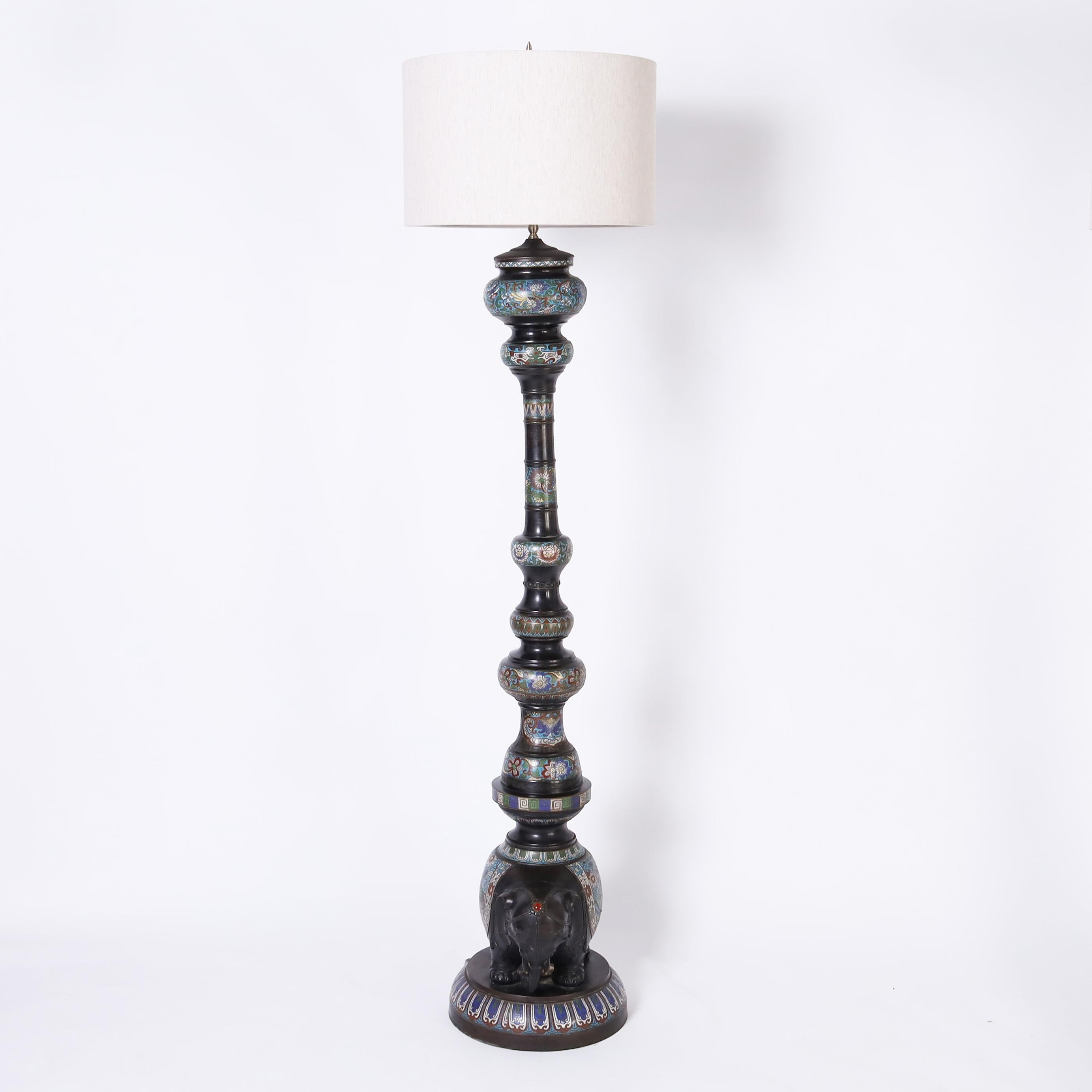 Impressive 19th century pair of Japanese floor lamps, once oil lamps, crafted in bronze with a dark lush patina and decorated with enamel in a champlevé technique in floral designs with birds, featuring elephants as bases with cabochon stone