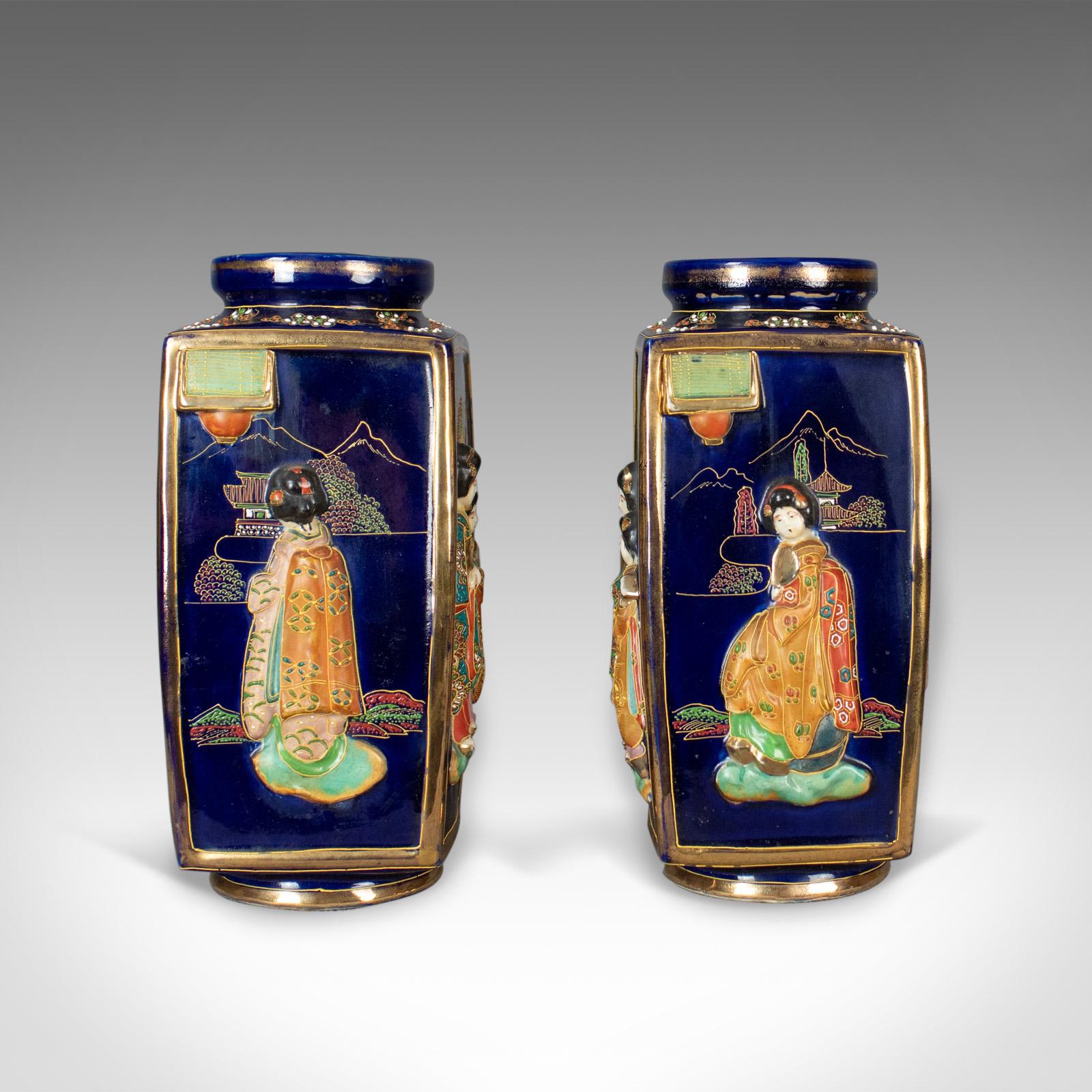 This is an antique pair of Japanese vases, ceramic pots dating to the 20th century.

Profusely decorated pair of ceramic vases
Free-from any damage or marks
Scenes of ladies in kimonos, pagodas, trees and mountains
Deep blue ground with gold