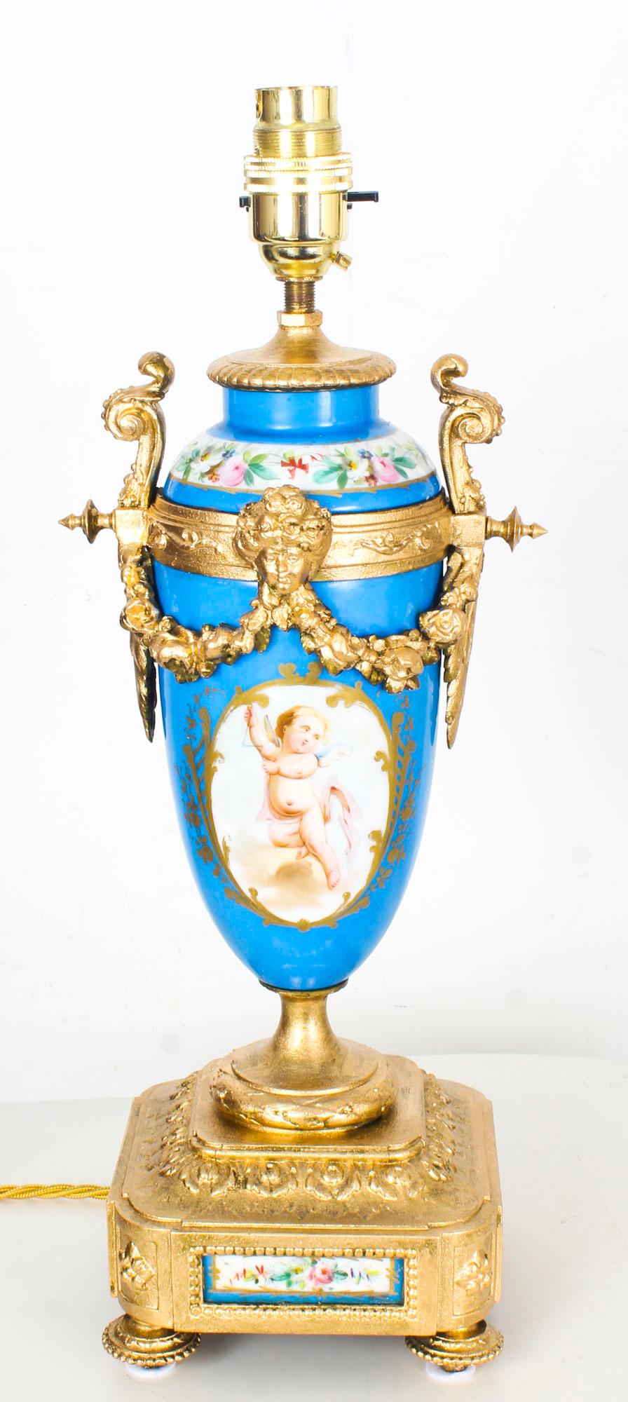 This is a beautiful antique pair of French Sevres porcelain vases converted to lamps, dating from the late 18th century.

The decorative twin handle vases are superbly decorated with hand-painted panels of romantic cherubs on one side and bouquets