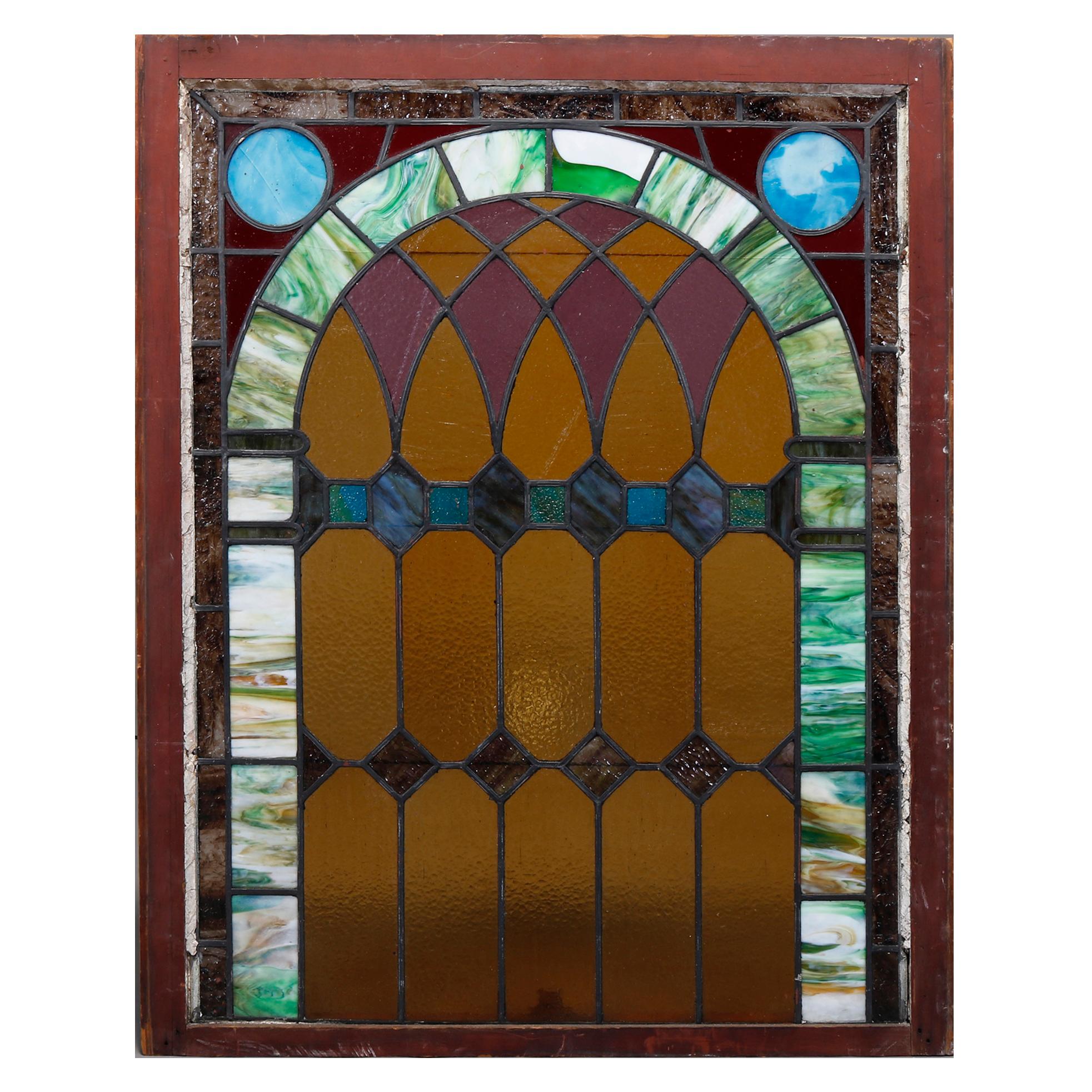 An antique set of two leaded stained and slag glass windows offer geometric and arched design, architectural elements, one with wood frame, 19th century

Measures: With frame 43