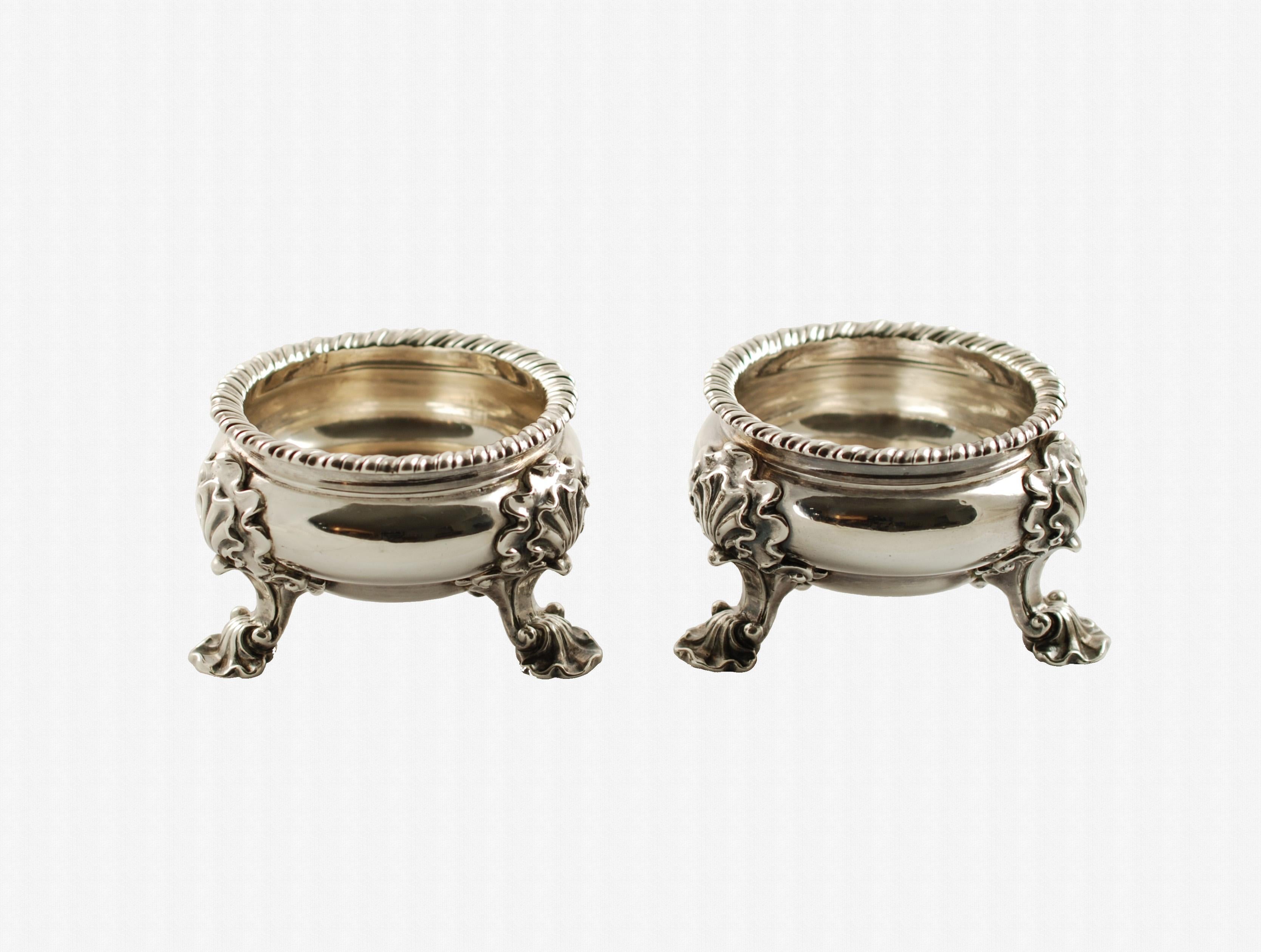 This substantial pair of English sterling silver master salts were made in 1741-1742 during the reign of King George II by London silversmith Lewis Pantin I. The bowls have a gadroon edge and rest on three ornate shell form feet. The set displays
