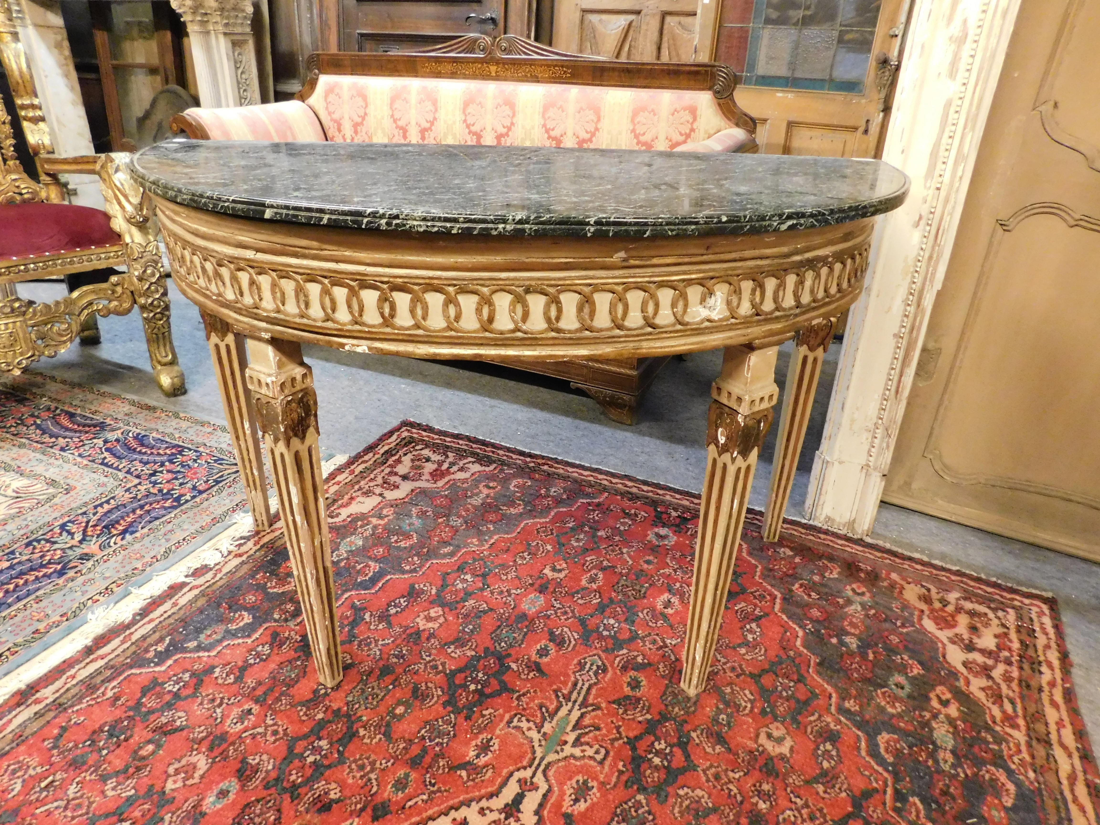 Antique pair of Louis XVI console in lacquered and gilded wood, with top in Italian green marble, half-moon shaped table, rare in pair and beautiful accompanied by equal mirrors.
The finishes are precious, elegant and embellished with gold and