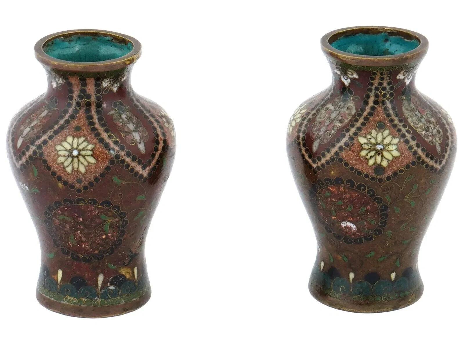 Pareja de antiguos jarrones japoneses de cloisonné del periodo Meiji, de forma elegante con hombros altos y esmalte de color marrón saturado. Decorado con motivos de mosaico con imágenes florales multicolores en el cuerpo. El borde y la base están