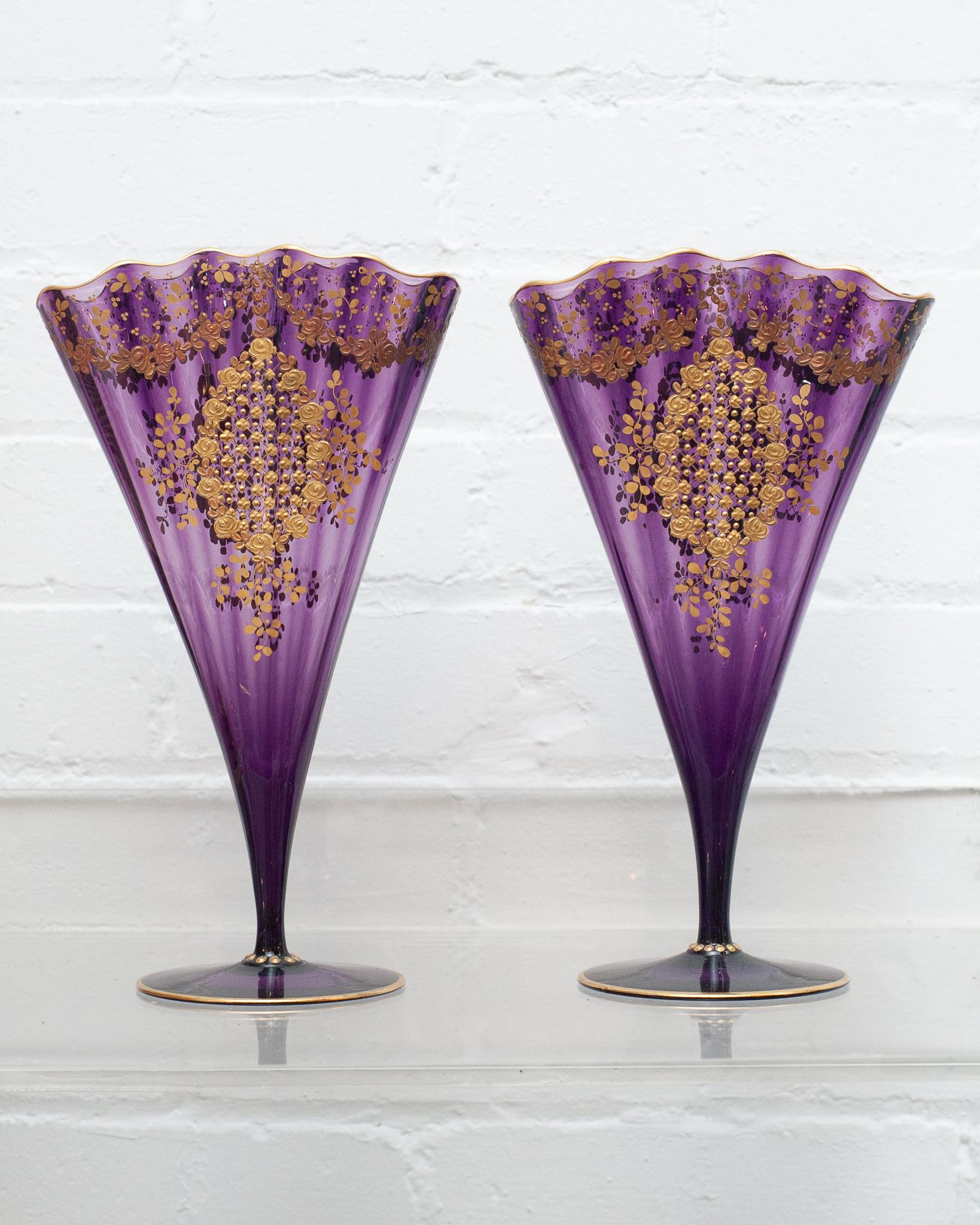 A spectacular pair of antique Moser purple amethyst fan vases with ornate gold gilding. Produced in the early 20th century, these vases are in perfect condition and showcase fine craftsmanship. Their vibrant amethyst purple tone highlights the