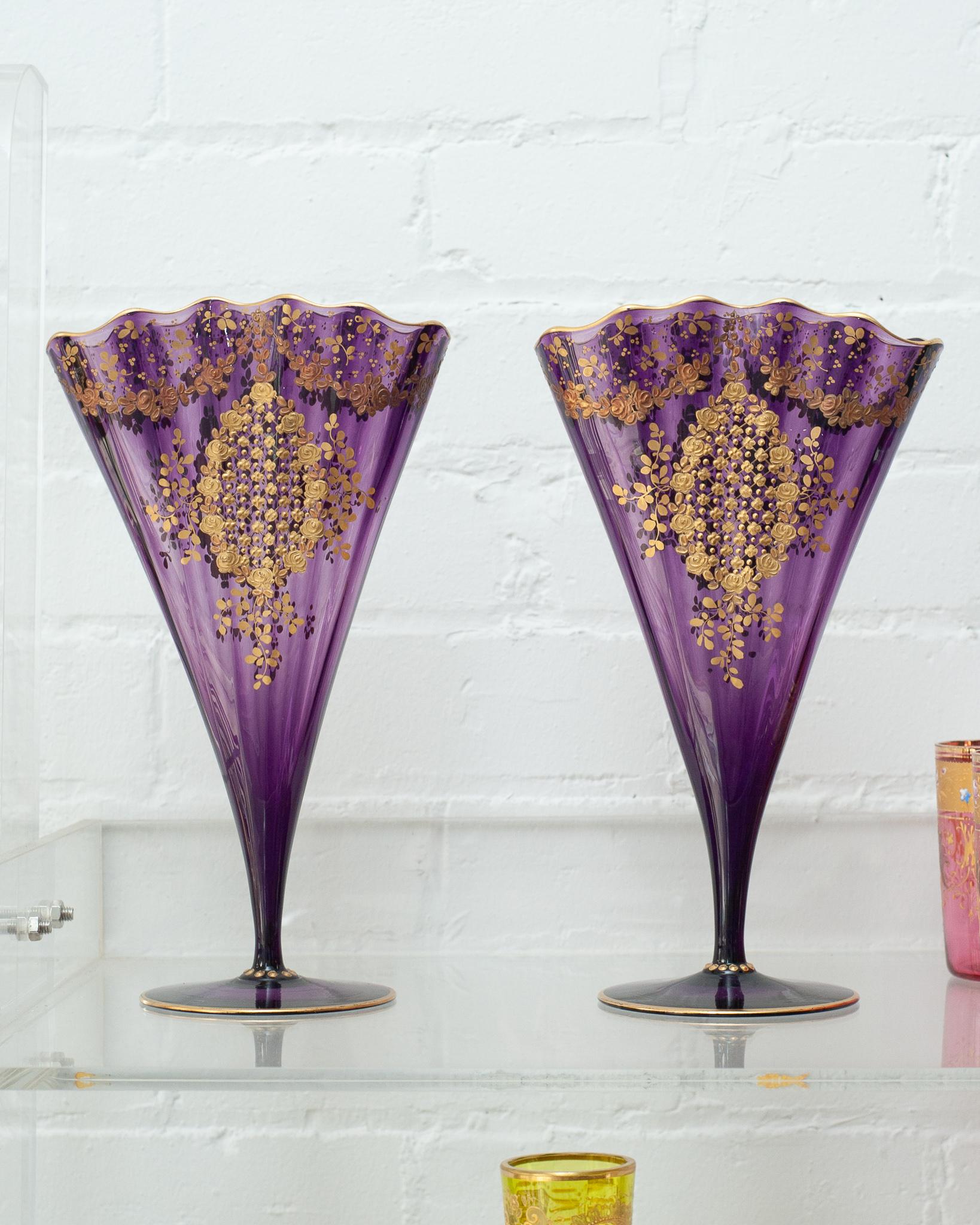 A spectacular pair of antique Moser purple amethyst fan vases with ornate gold gilding. Produced in the early 20th century, these vases are in perfect condition and showcase a fine craftsmanship. Their vibrant amethyst purple tone highlights the
