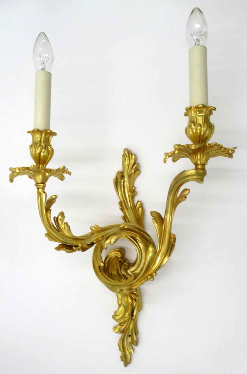 Fine quality pair of French Napoleon lll gilt bronze extremely heavy gauge twin arm wall candle sconces lights, of very generous proportions and outstanding quality, mid-19th century..

The twin leaf capped scroll arms chisel cast depicting