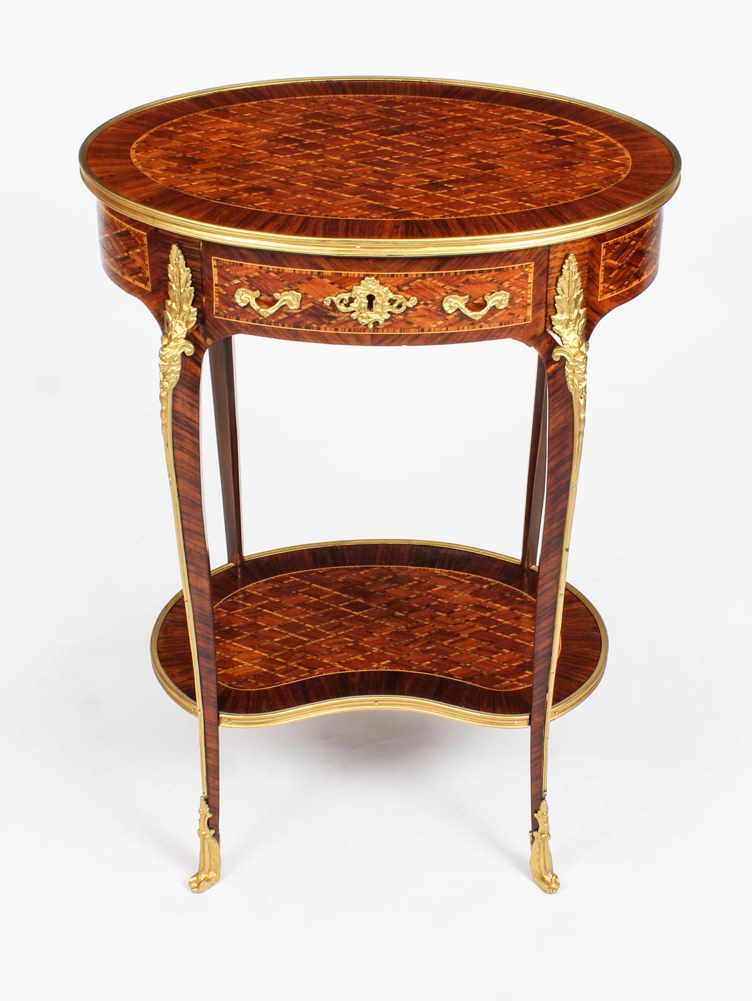This is a beautiful pair of antique French Louis Revival parquetry occasional tables, late 19th century in date.

The gilt-bronze banded oval table tops are beautifully inlaid with diamond-shaped parquetry above a frieze with a single drawer. The