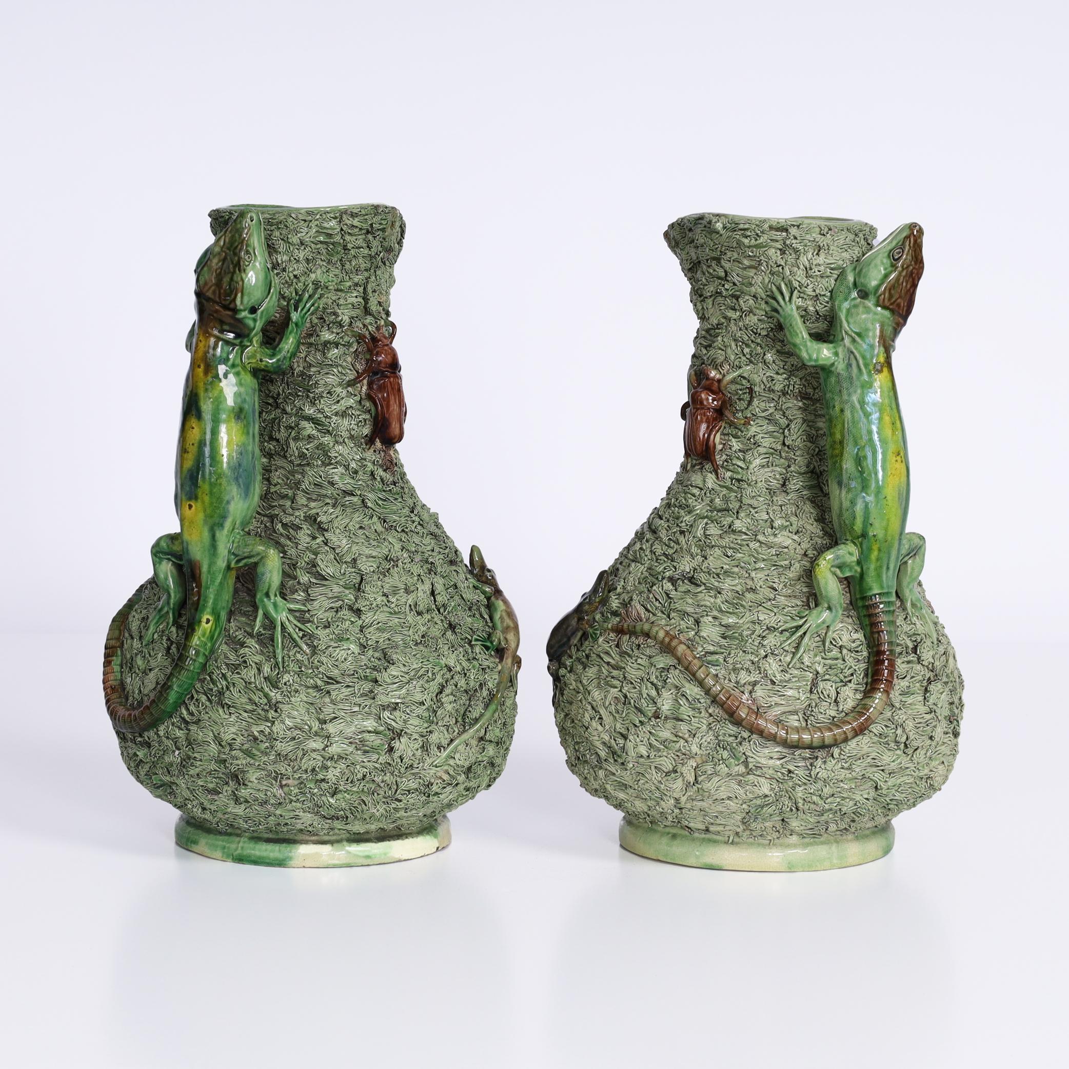Remarquable paire de pichets portugais en terre de Palissy du XIXe siècle, fabriqués à la main en faïence ou en argile, recouverts de glaçures colorées et décorés d'un éventail fantaisiste de reptiles, d'insectes et de lézards en guise d'anses. Le