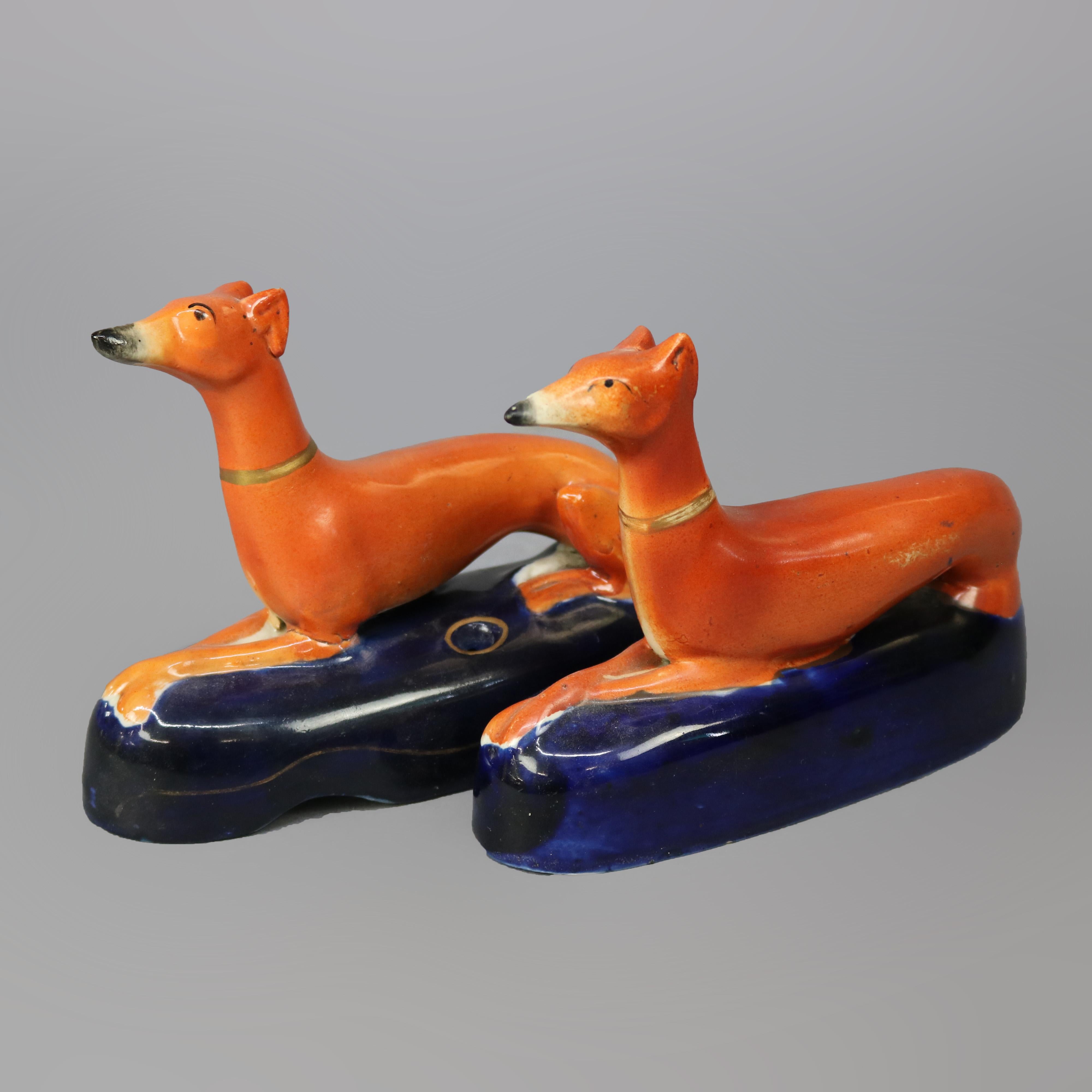 An antique pair of figural inkwells by Staffordshire offer pottery construction in whippet (dog) form, hand painted with gilt highlights, pen receivers as photographed, 19th century

Measures - 5''H x 2''W x 6.25''D.