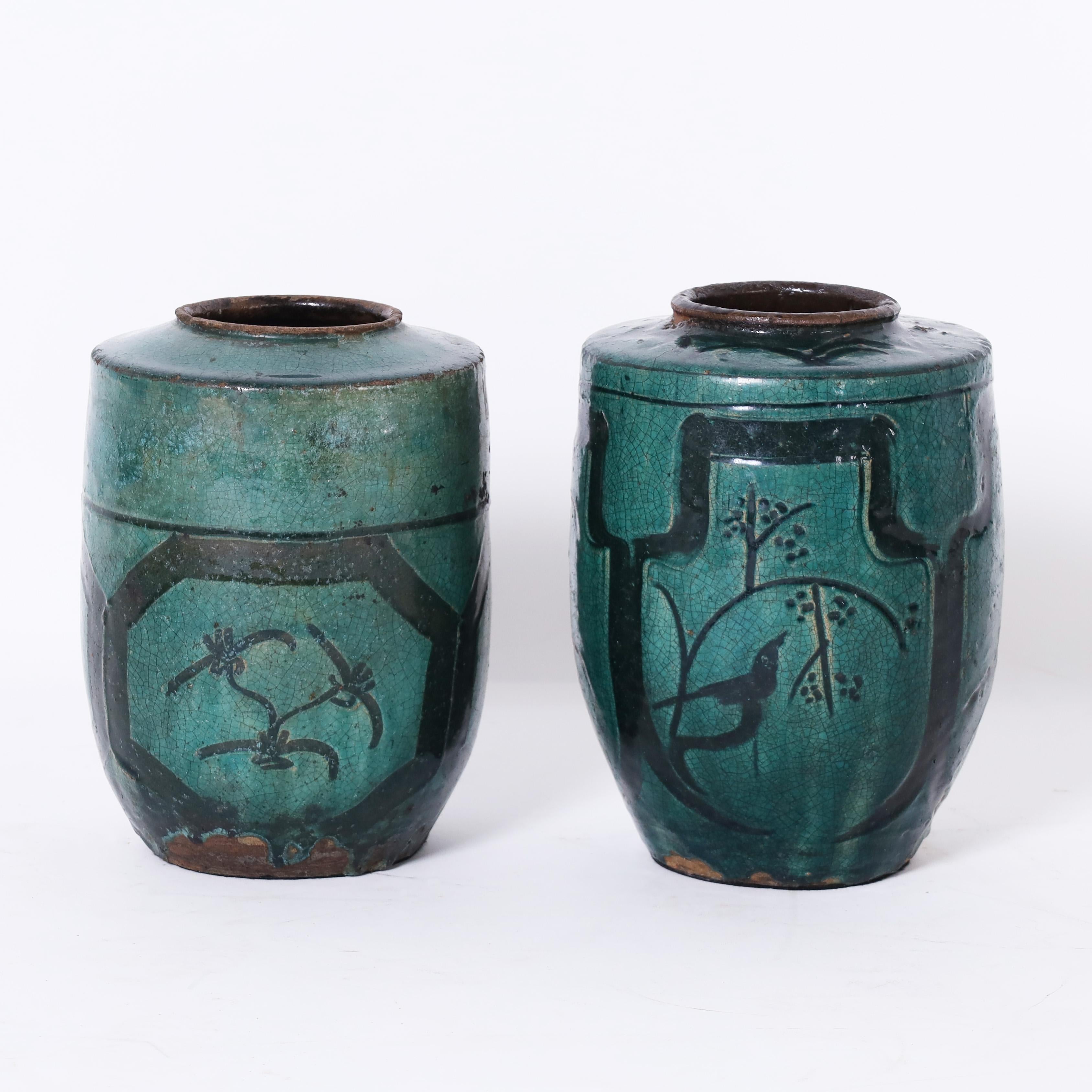 Rare et inhabituelle paire de vases persans du XVIIIe siècle fabriqués à la main en terre cuite et décorés d'oiseaux, de fleurs et d'un motif asiatique non conventionnel, puis émaillés, aujourd'hui craquelés et vieillis à la perfection.