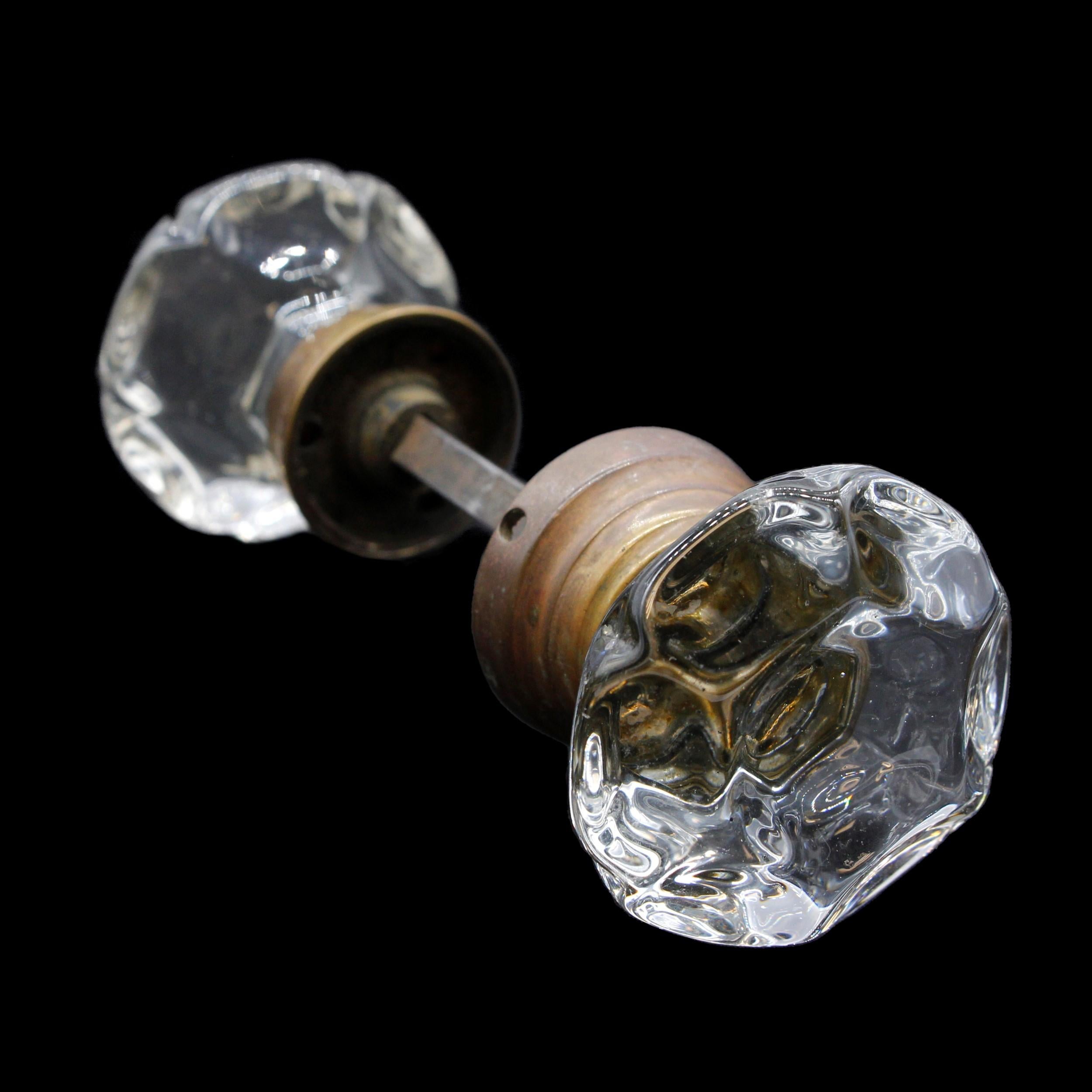 Unusual pair of early 20th Century doorknobs. These feature a center X and punted glass design. Brass hardware. This can be seen at our 400 Gilligan St location in Scranton, PA.