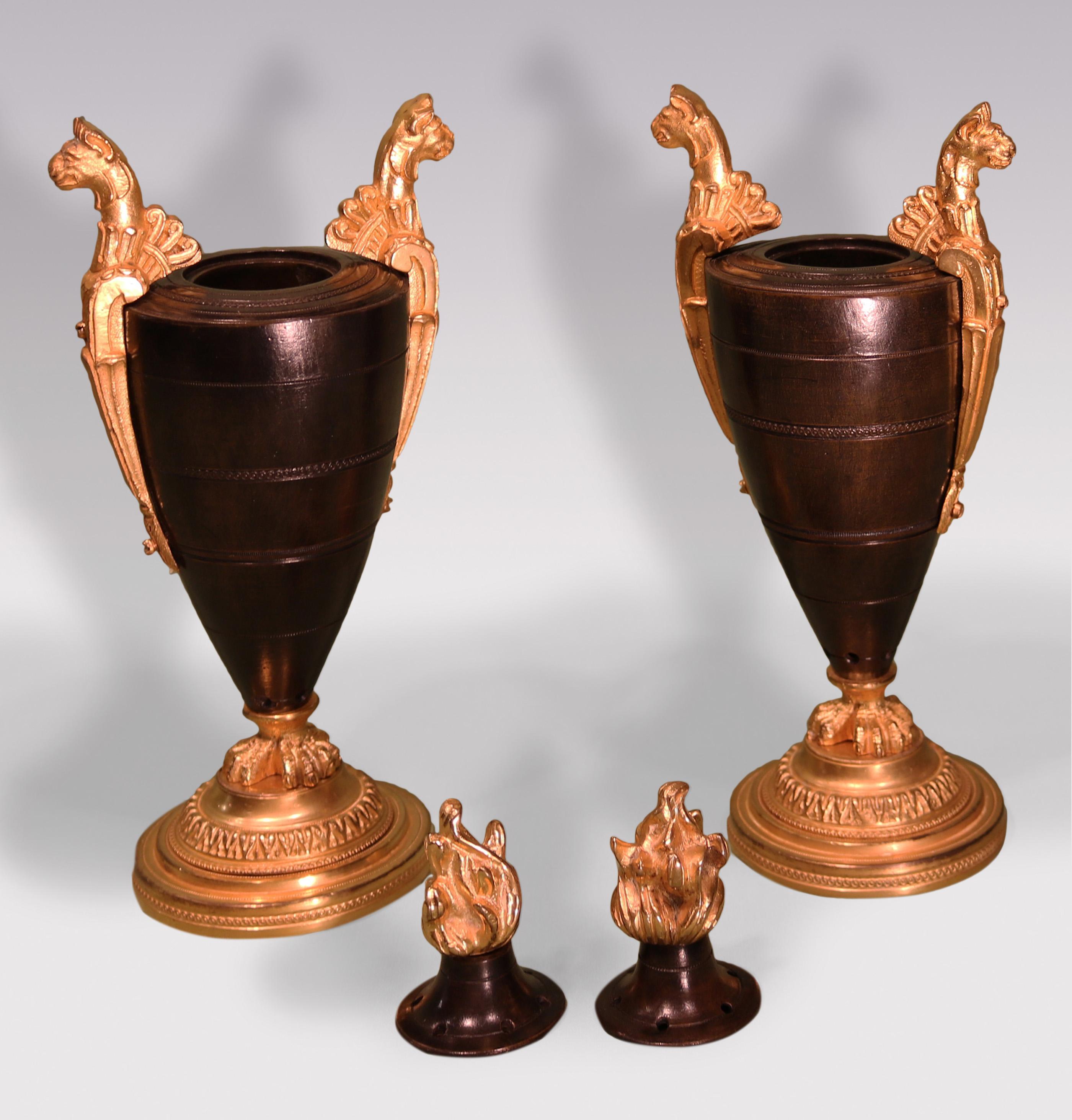 An unusual Pair of early 19th Century bronze & ormolu Parfumiers in the form of urns with flame lids flanked by anthemion leopard handles, raised on triple feet ending on engine-turned circular bases.