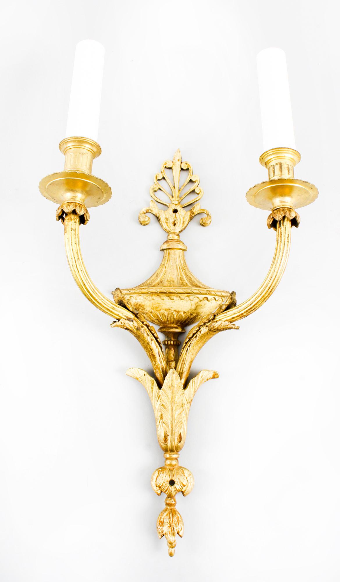 This is a stunning pair of Regency style twin branch ormolu wall lights dating from the late 19th century.

The lights feature classical Regency elements with anthemion, classical urn and palmette cast backplates issuing twin reeded scrolled