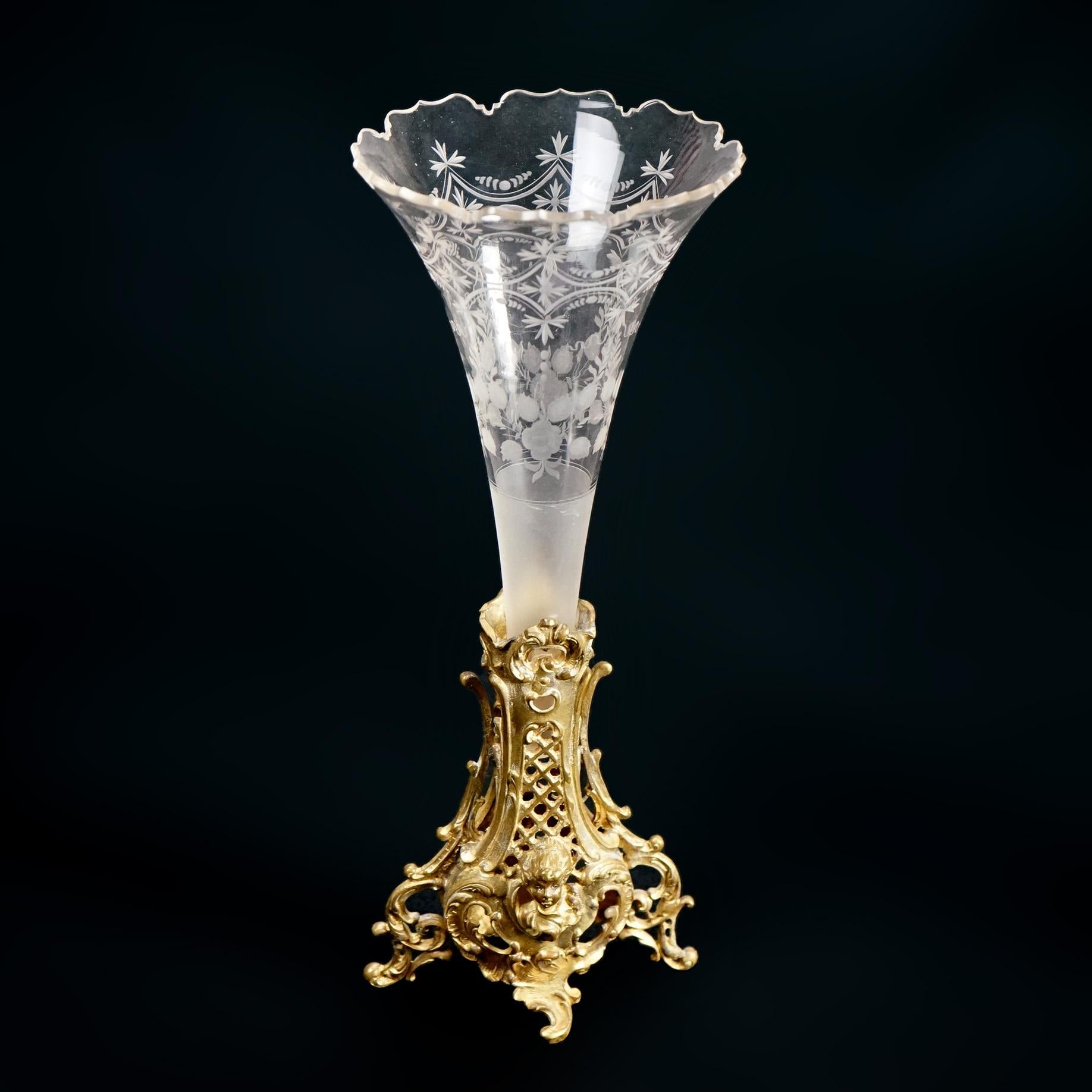 An antique pair of French Rococo trumpet vases offer floral etched and cut glass vessels seated in cast ormolu base having foliate elements and masks, c1890

Measures- 14''H x 5.75''W x 5.5''D