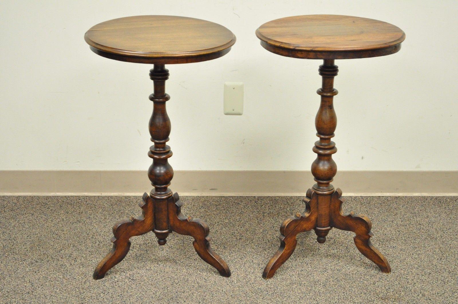 Pair of antique American Colonial round turn carved walnut handmade pedestal base side tables. Item features solid walnut construction, turned carved pedestal bases, tripod legs, old repairs which adds character. Great antique tables, circa 19th
