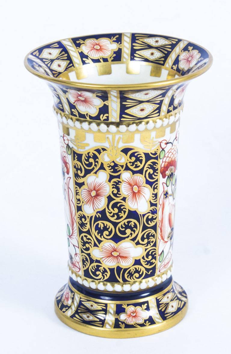 This is a truly superb pair of hand-painted Royal Crown Derby porcelain trumpet shaped spill vases, with date code for 1919.

Beautifully hand painted in the Imari pattern with beaded girdles, exquisite gilded decoration and bearing the red
