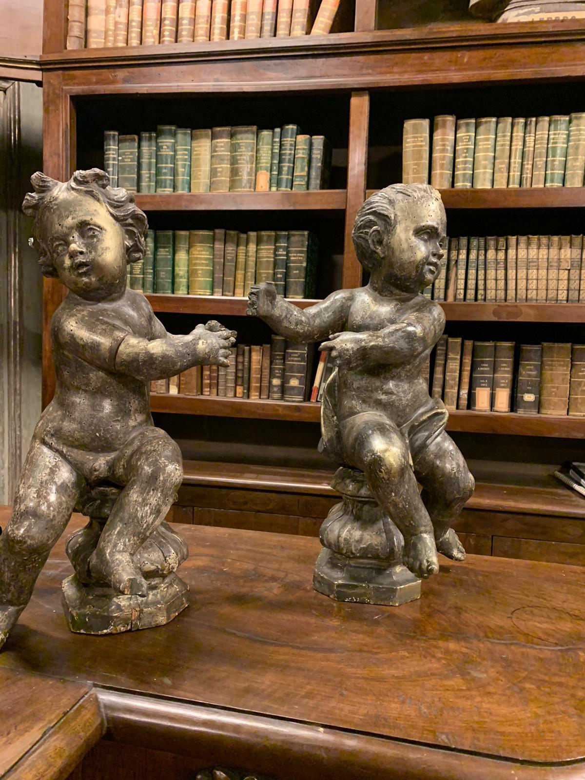 Ancient pair of sculptures, figures of wooden cherubs, carved by hand and complete with Coeval base, original silver and gilded finish, ptina of the past, hand-built in the 18th century for church in Italy.
Ideal for decorating niches, on important