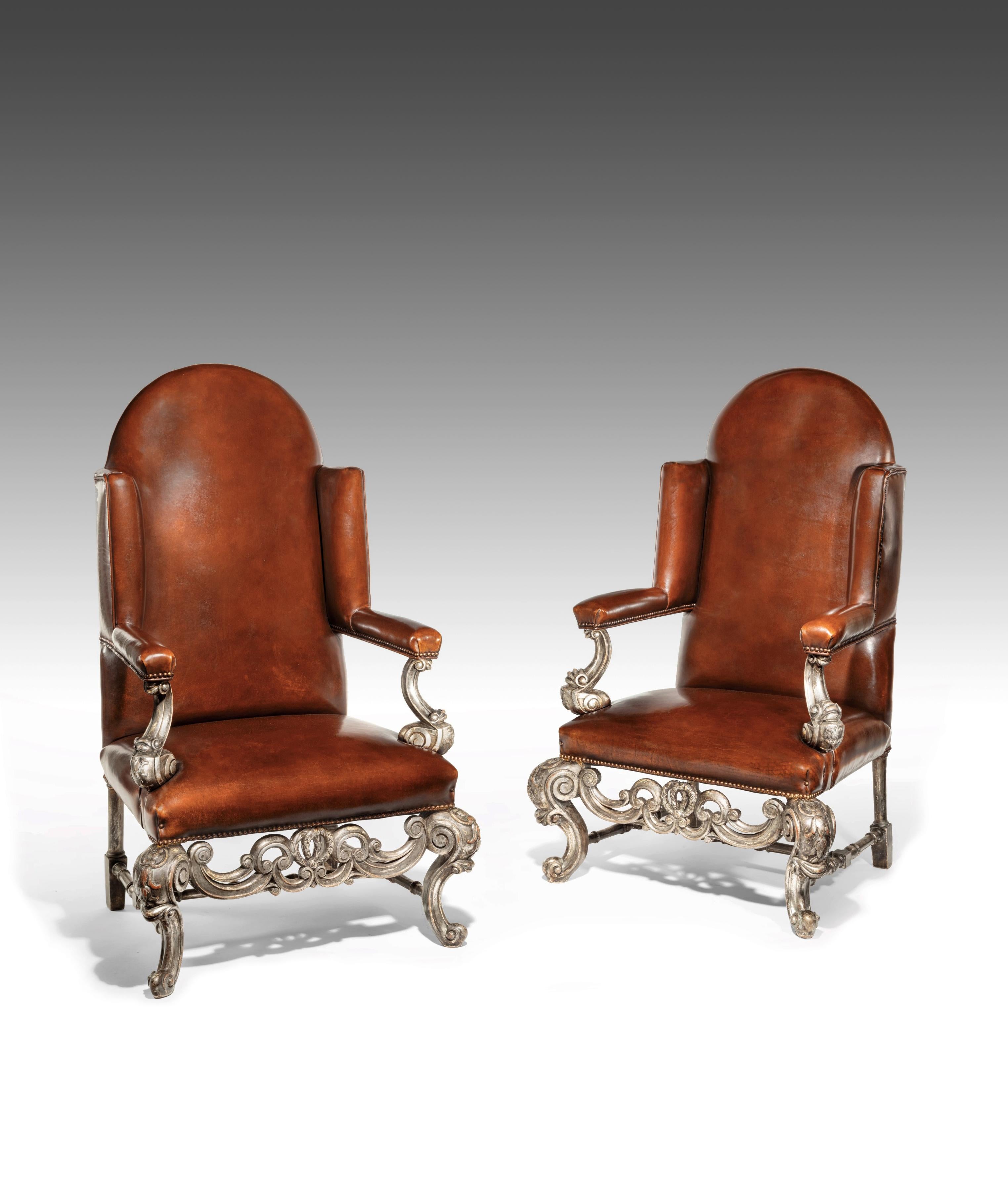 A very unusual and good quality pair of silver gilt leather upholstered wing armchairs dating to circa 1880 -1900.
This decorative and rare pair of leather upholstered wing armchairs have been constructed in the William and Mary style. With domed