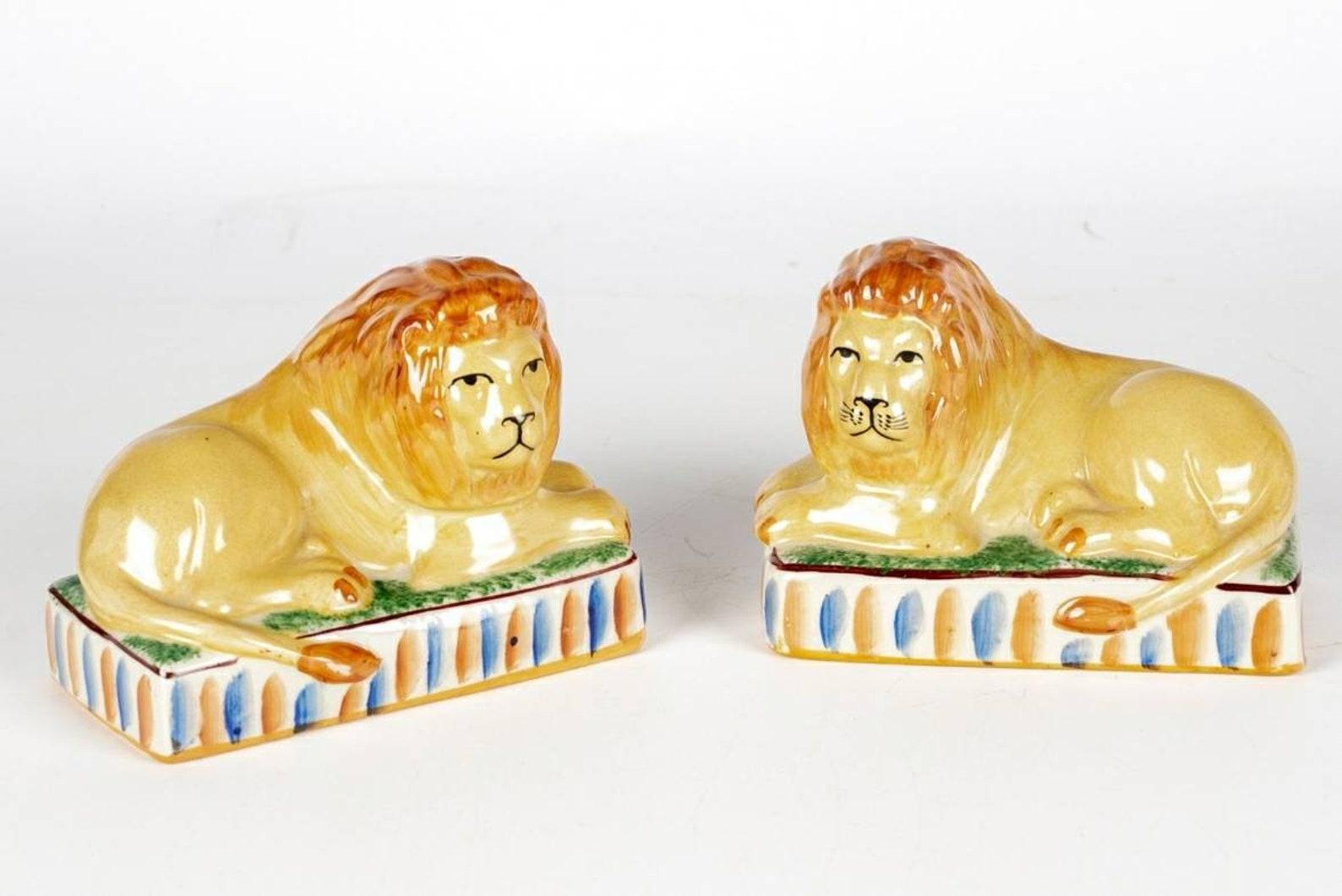 A charming original pair of antique Staffordshire style recumbent lions on striped rectangular plinths. Hand-crafted, rich coloring with beautifully aged patina, desirable crazing adds lovely unique character. Very good condition. 

Dimensions: