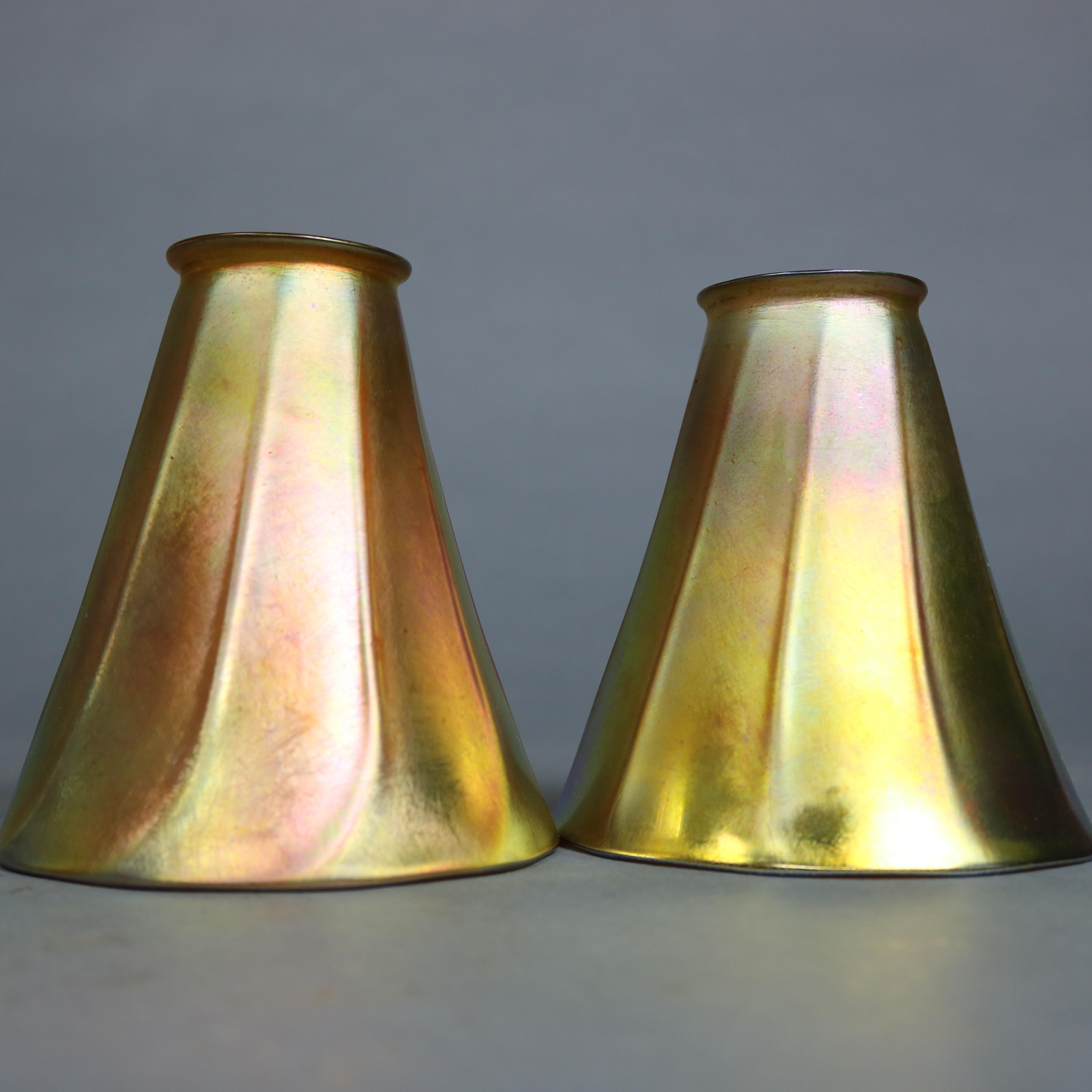 A pair of antique Arts & Crafts art glass shades by Steuben offer faceted and twisted form in gold aurene finish, circa 1920.

Measures: 5.5