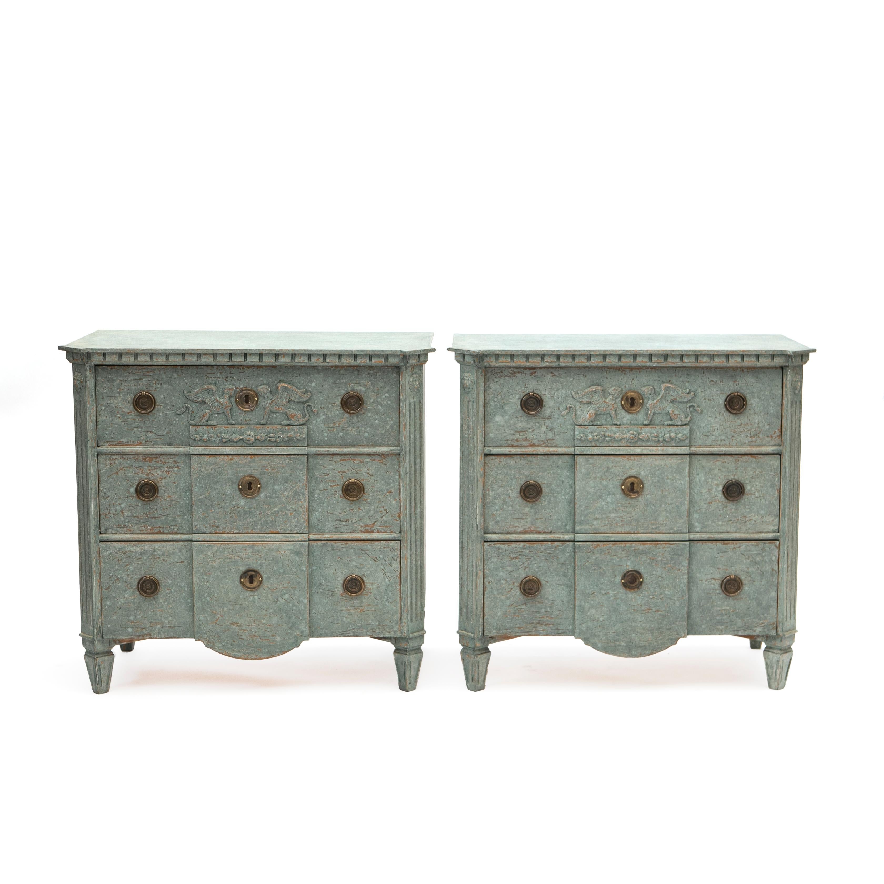 A pair of Swedish Gustavian style breakfront chest of three drawers, dating from the 19th century, painted in a light blue-green color scheme.

Each chest features a top with canted corners sitting above a front with three break drawers, top drawers