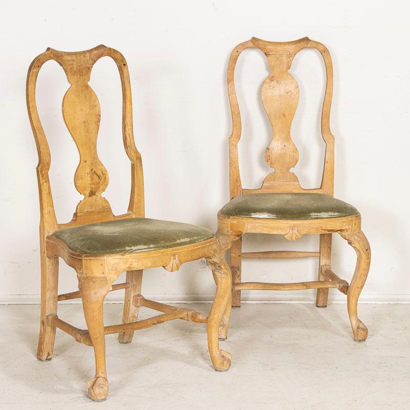The curves and graceful lines of this pair of rococo style arm chairs reveal classic Swedish styling. The aged birch patina is worn and wonderful in this very 