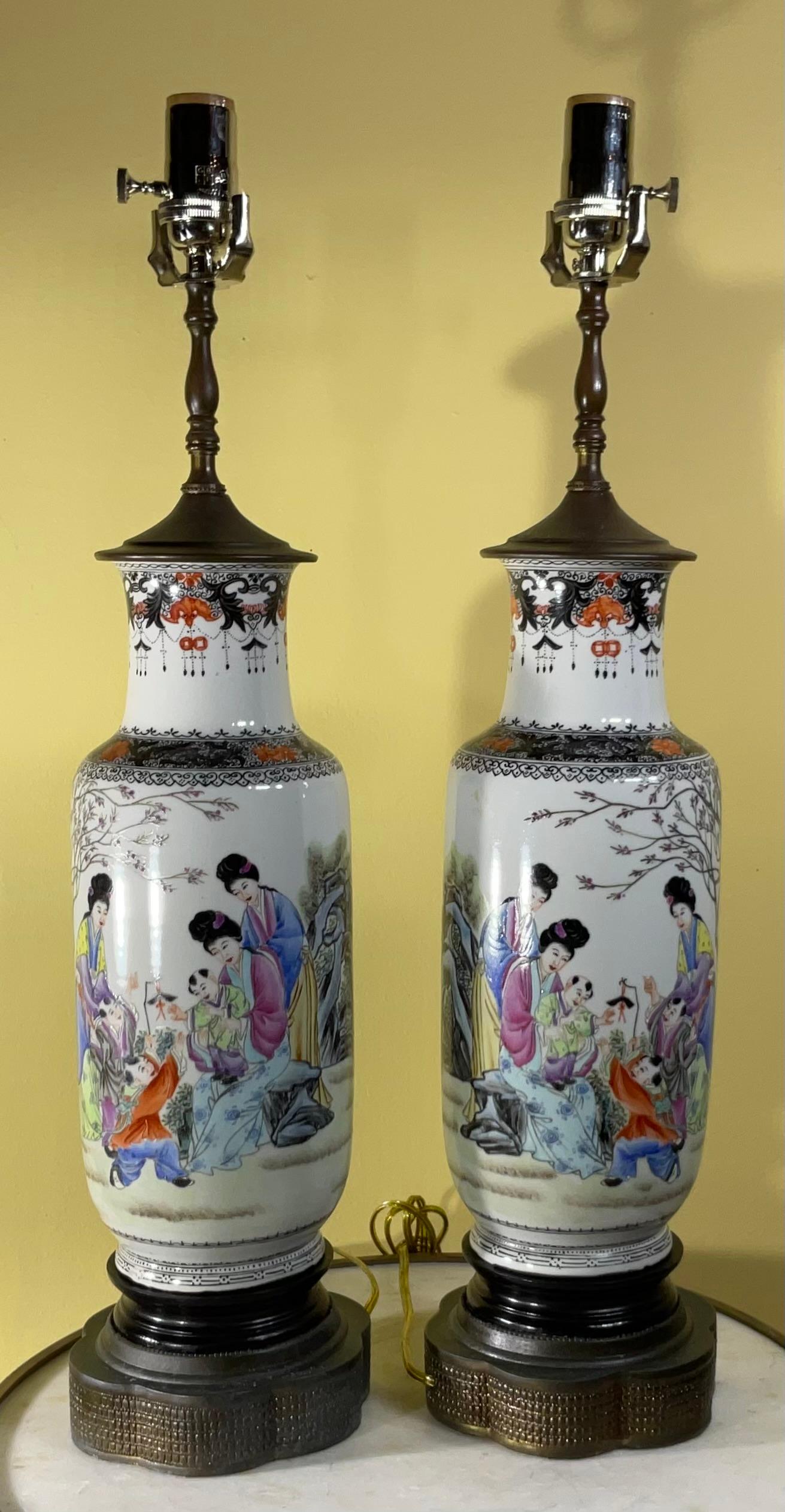 Exceptional  pair of Chinese table lamp hand painted on porcelain, beautiful colors of form of ceremony with families and there  children in the garden , in The back is Chinese script which I have not deciphered. The neck has scrolling border of