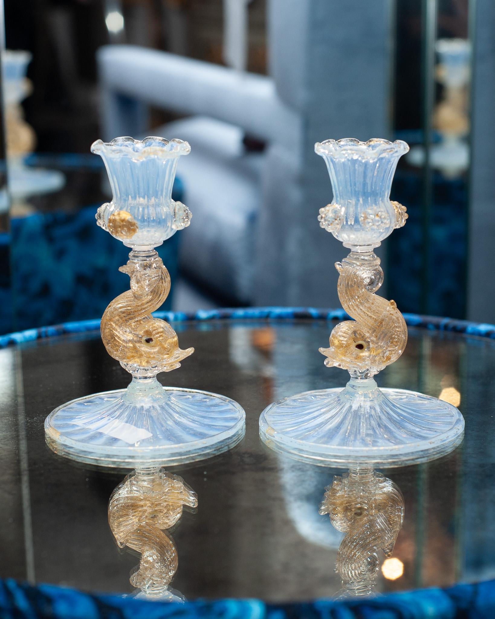 A stunning pair of antique Venetian murano glass candlesticks in opalescent glass and gold leaf with dolphin motif. They are a perfect smaller size candlestick and are beautifully made. These candlesticks would make a gorgeous addition to any table. 