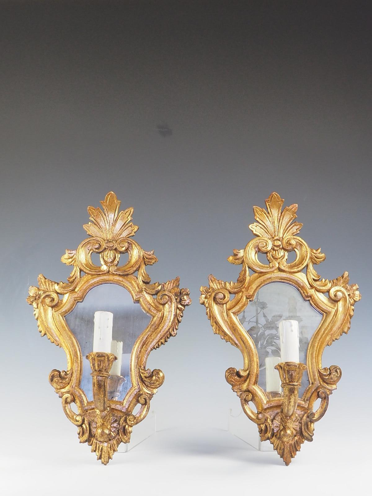 A stunning pair of Venetian ‘Girandole’ wall mirror lights, meticulously crafted with exquisite details. These wall lights feature finely carved, painted, and gilt timber frames that exude elegance and sophistication.

Adorned with their original,