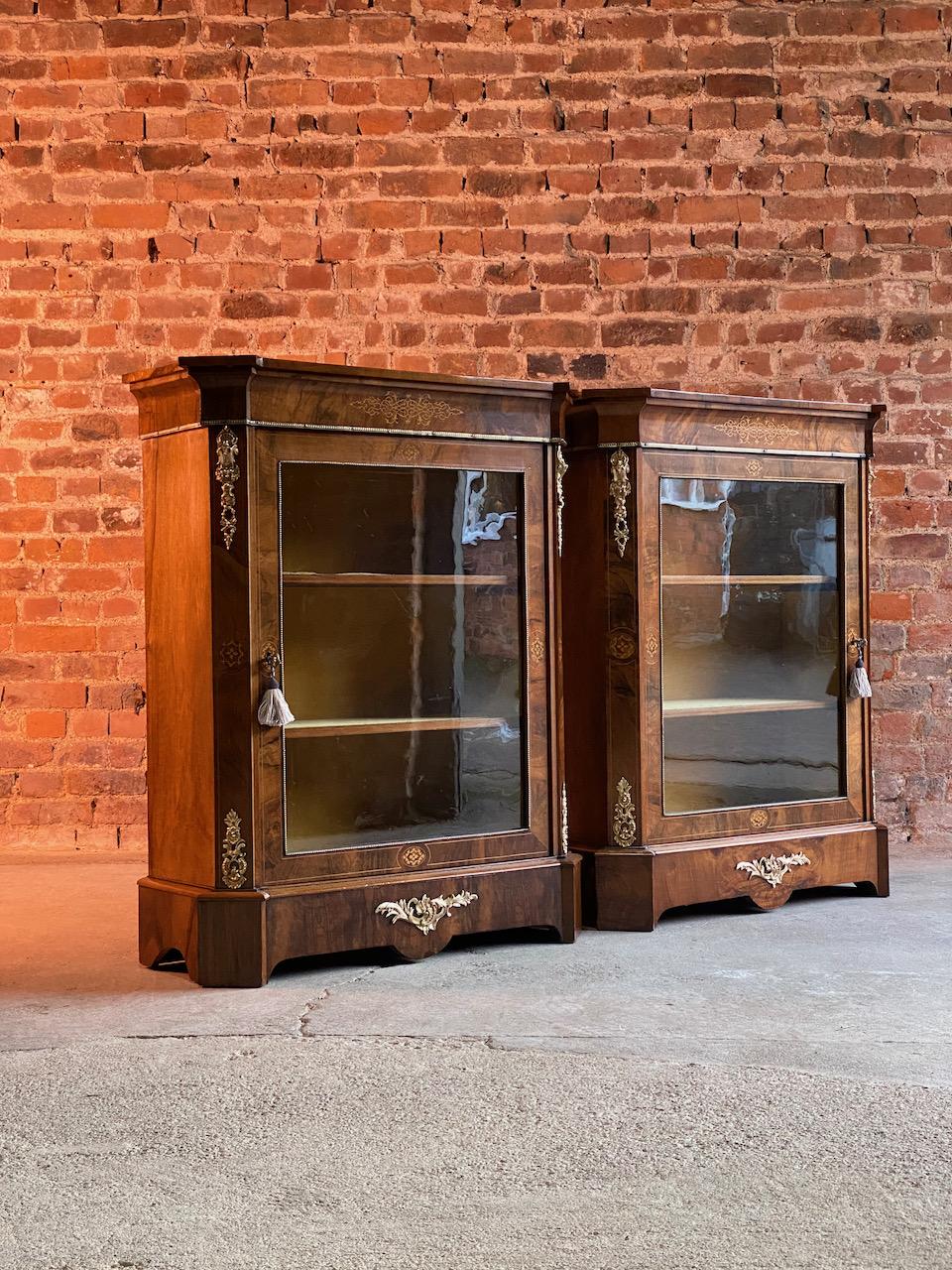 Antique pair of walnut pier cabinets Victorian, circa 1880

Pair of late 19th century Victorian inlaid walnut side or pier cabinets England circa 1880, each of canted breakfront form, the figured top over foliate scroll-inlaid frieze and