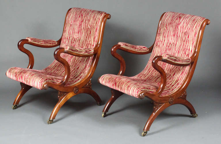 A pair of Regency mahogany x-frame library chairs with good carved detail.