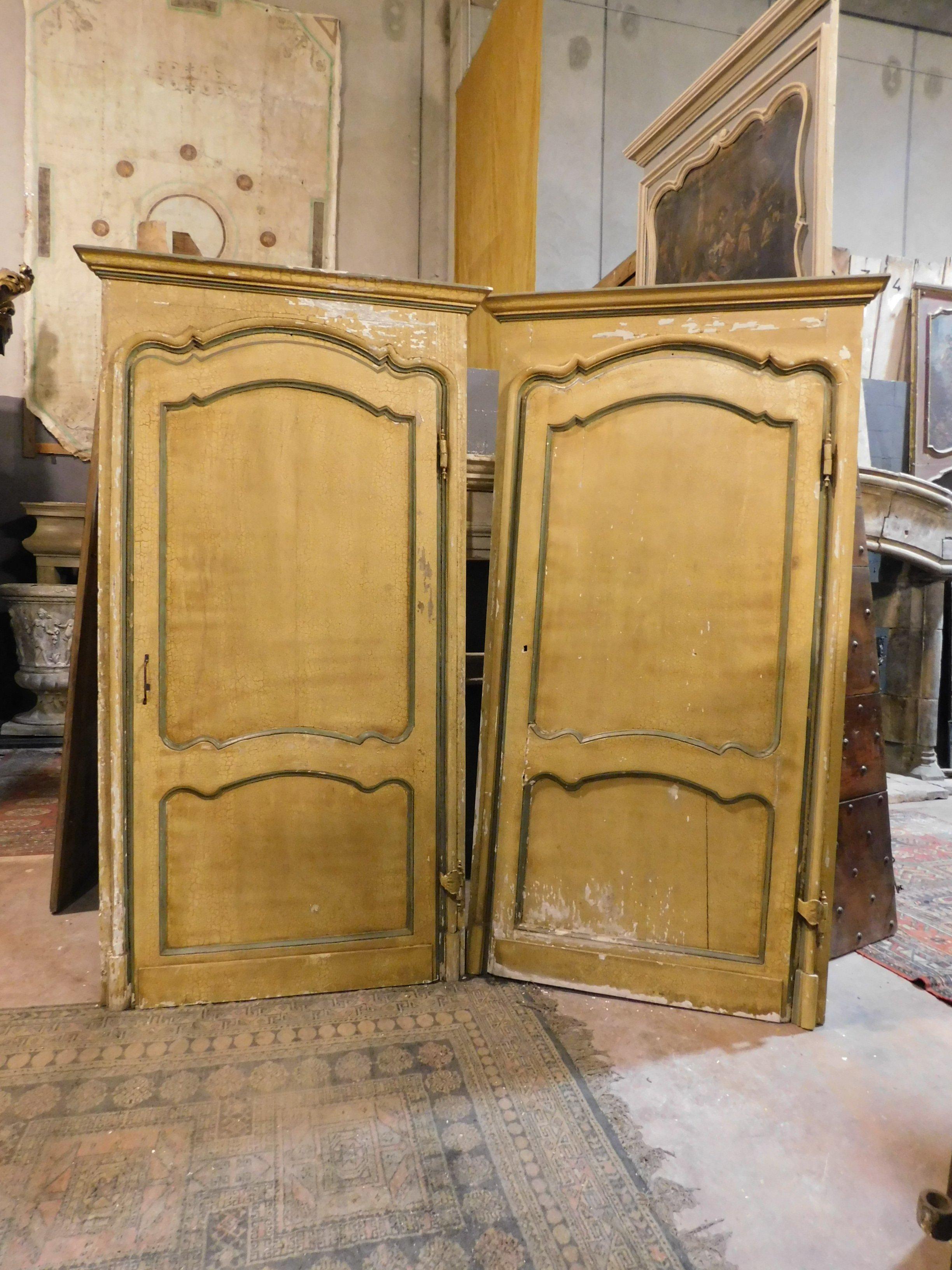 Antique pair of lacquered doors, yellow with green moles, with wavy sculpted panels and original frame, beautiful original gooseneck irons, built entirely by hand in the late 1700s for an important building in Italy.
With a finished panel also on