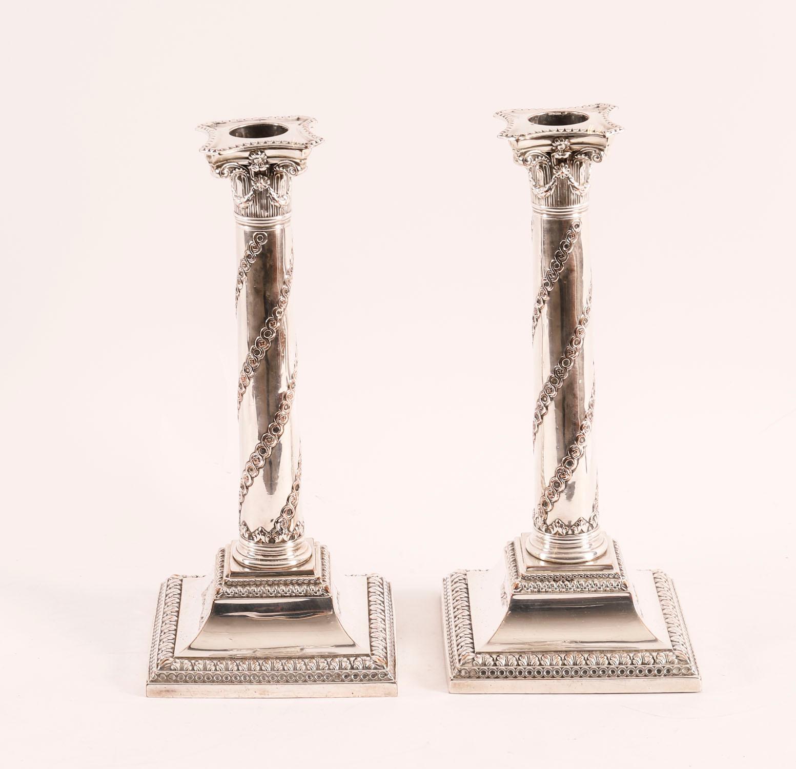 This is an elegant pair of antique English George III Old Sheffield Plate candlesticks, in the Adam taste,  circa 1775 in date.

The candlesticks are of Corinthian design and have detachable sconces.  The bases of the sticks have two bands of