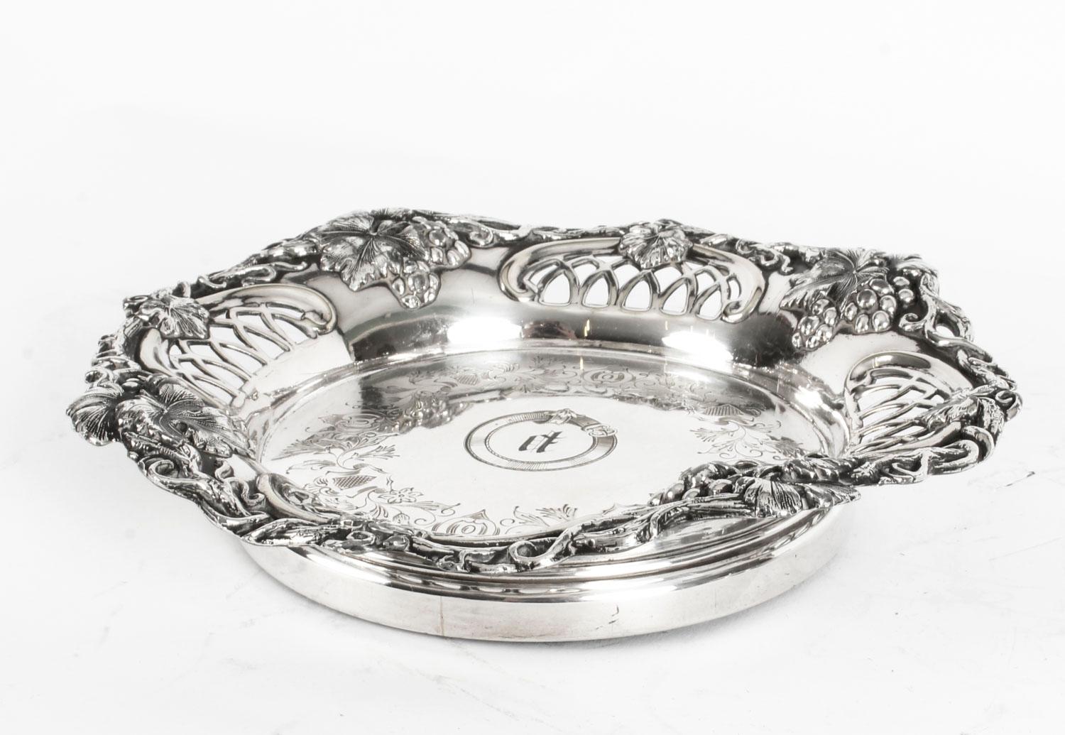This is a very attractive English George IV pair of antique Old Sheffield silver on copper wine bottle coasters, circa 1820 in date.

The shaped circular wine coasters feature exquisite vine and grape borders with pierced decoration, with floral