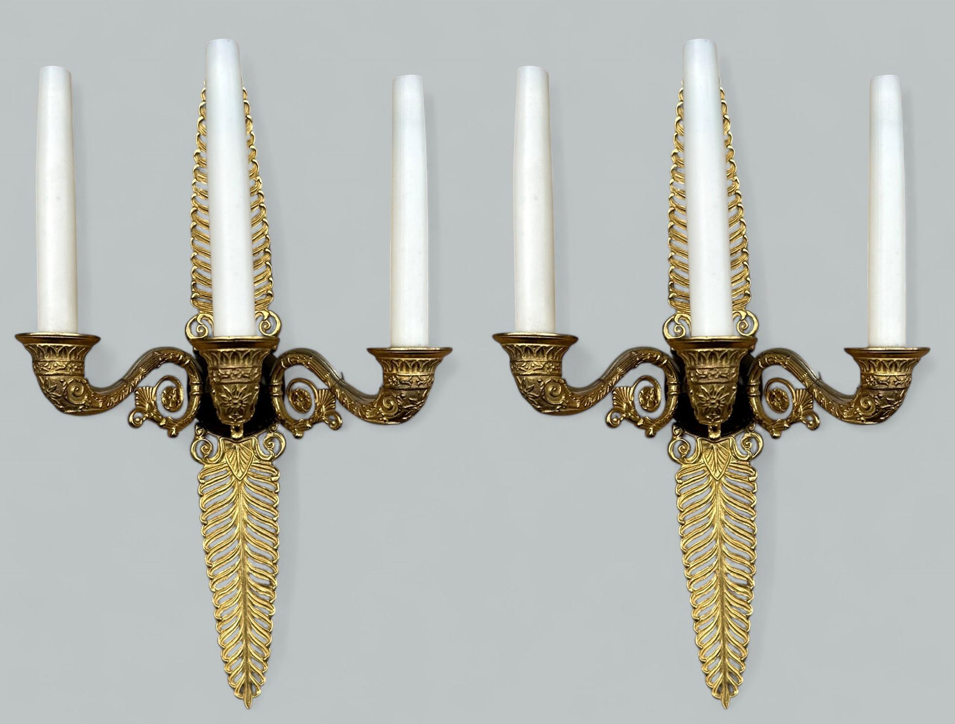 Fine Quality Pair of French Empire Gilt Bronze Three Arm Wall Candle Sconces Lights, of generous proportions, mid to late Nineteenth Century. 

The three leaf capped very ornate scroll arms issuing from patinated bronze circular support, the