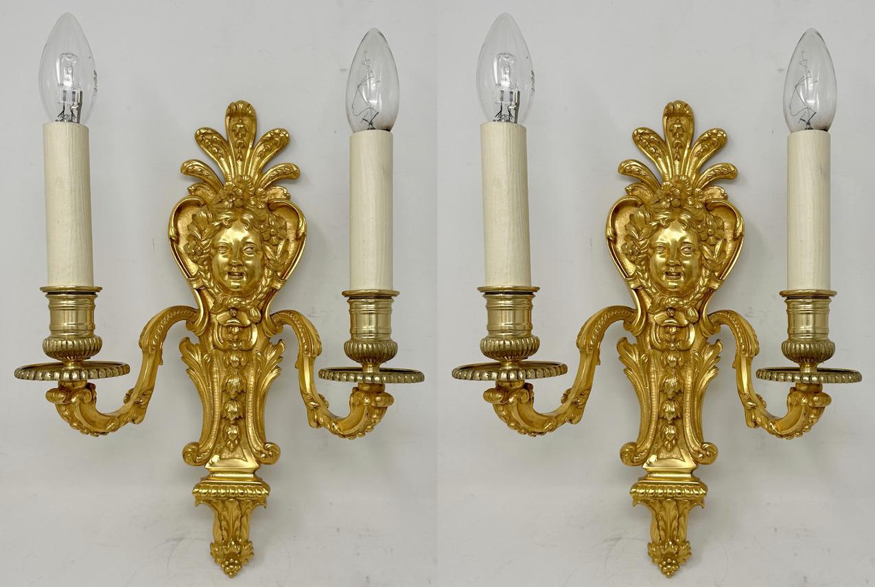 Fine Quality Pair of French Well Cast Heavy Gauge Gilt Bronze Two Arm Wall Candle Sconces Lights of generous proportions, now wired for electricity, late Nineteenth Century. 

Each two leaf capped scroll arms issuing from a single solid back plate