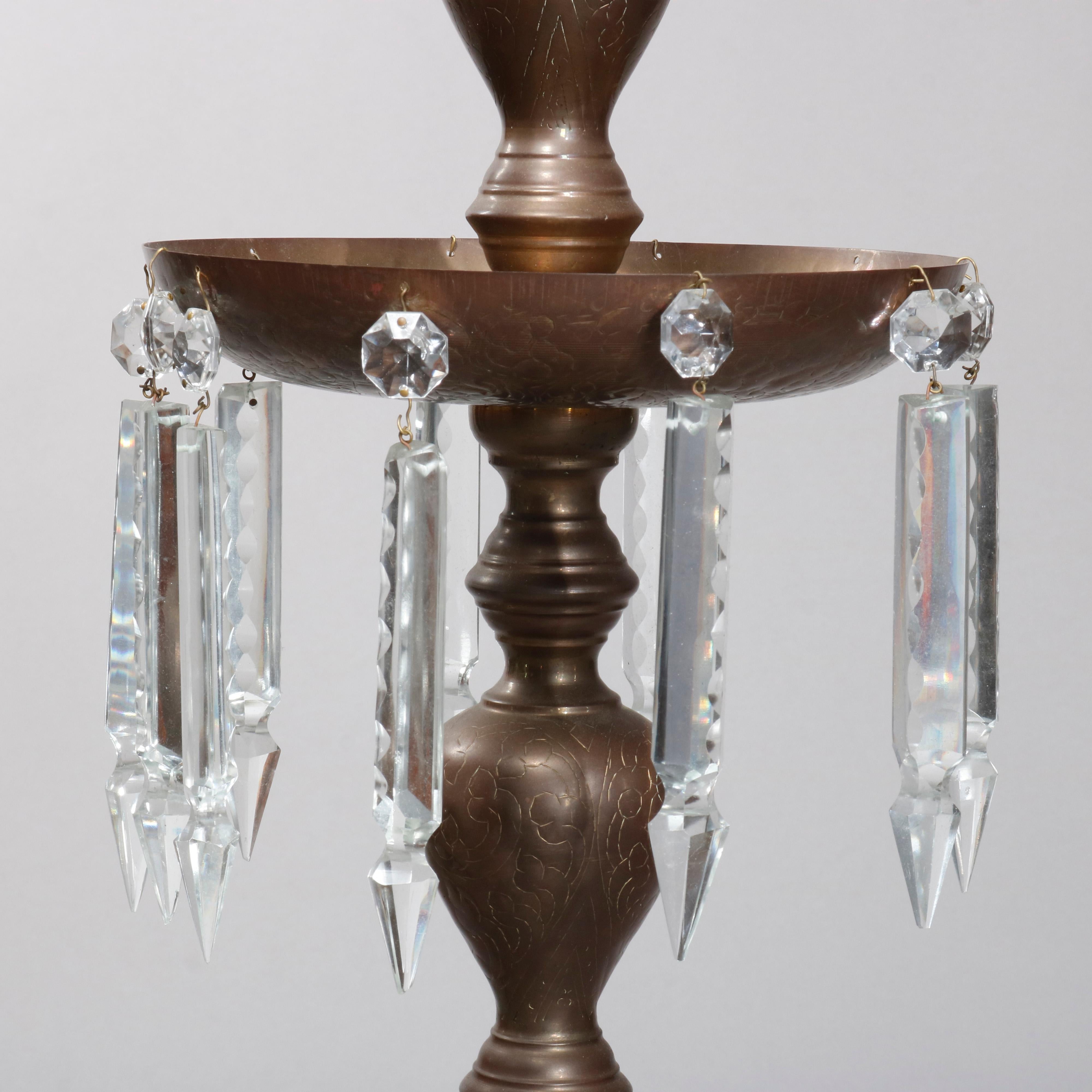 An antique pair of floor candelabra offer brass construction in balustrade form with bobeches having hanging crystals and Persian elements, circa 1930.

 Measures: 49