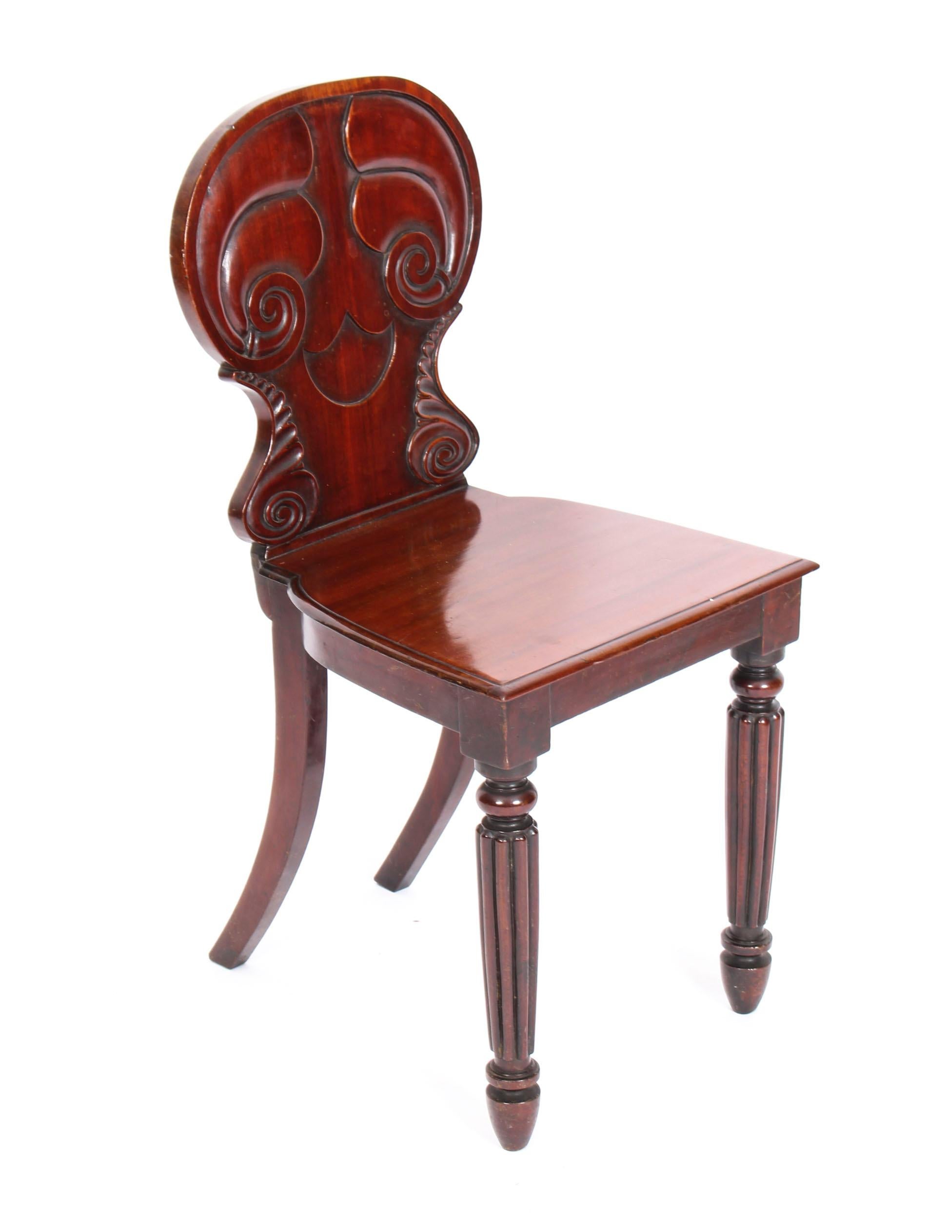 This is a wonderful antique pair of Regency mahogany hall chairs by Gillows Lancaster, circa 1820 in date.
 
These lovely chairs have been masterfully crafted in beautiful solid mahogany.
They feature scroll and foliate carved waisted backs above