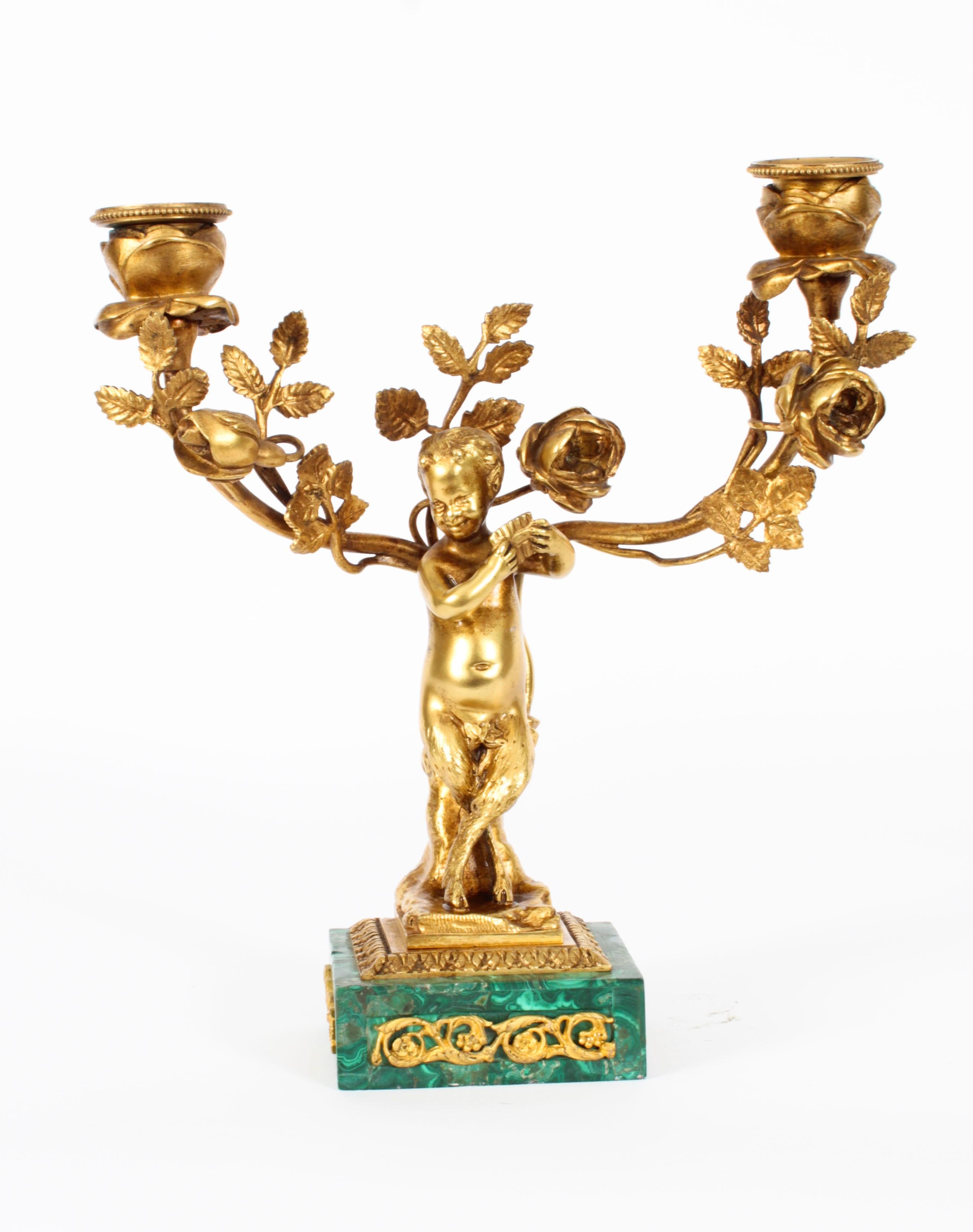 This is a magnificent antique pair of Russian gilt bronze and malachite candelabra, Circa 1900 in date.
 
The ormolu candelabra with floral branchwork supported by a pair of musical cherubs, one playing the triangle the other playing pipes.
