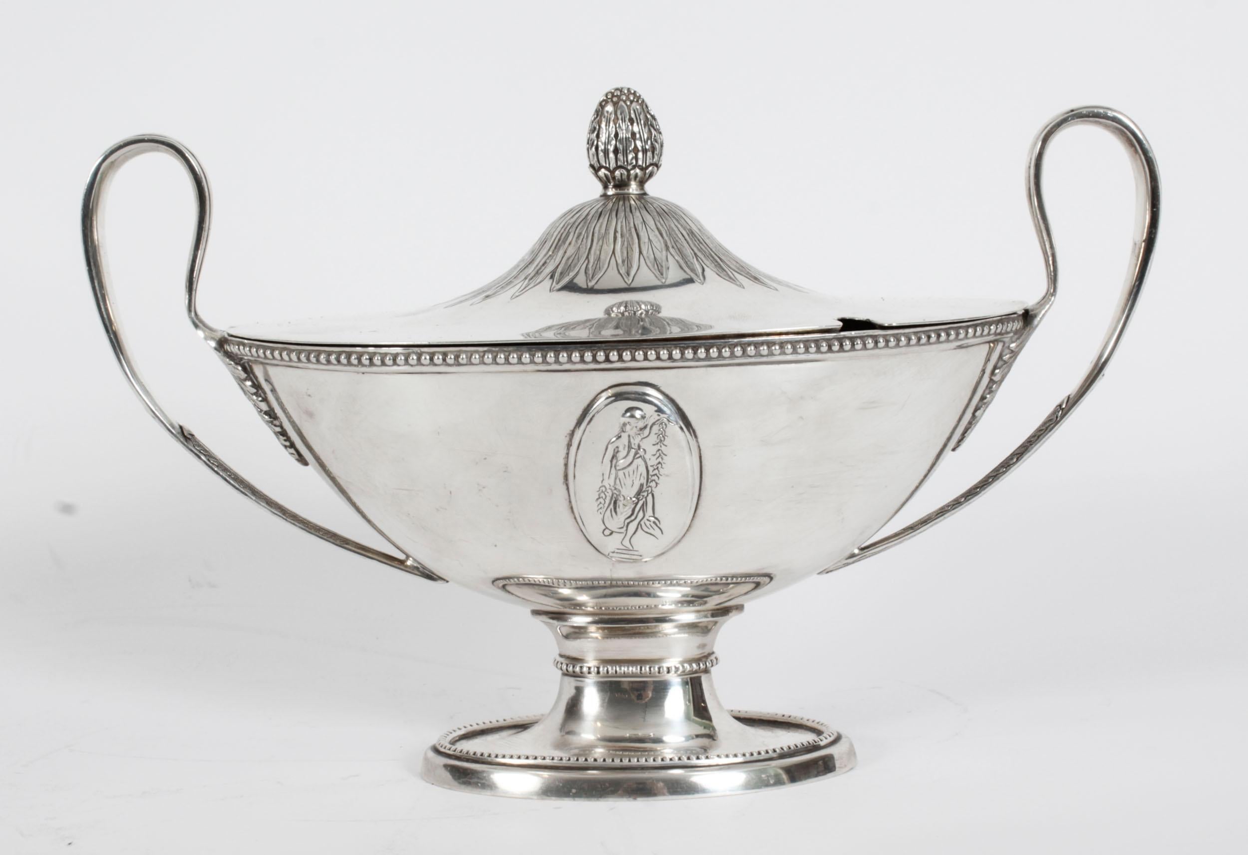 This is a exquisite and rare antique pair of English silver plated sauce tureens in the manne of Andrew Fogelberg, circa 1820 in date.
 
They are of classical urn shape each with a classical maiden plaque and featuring delightful beaded rims with