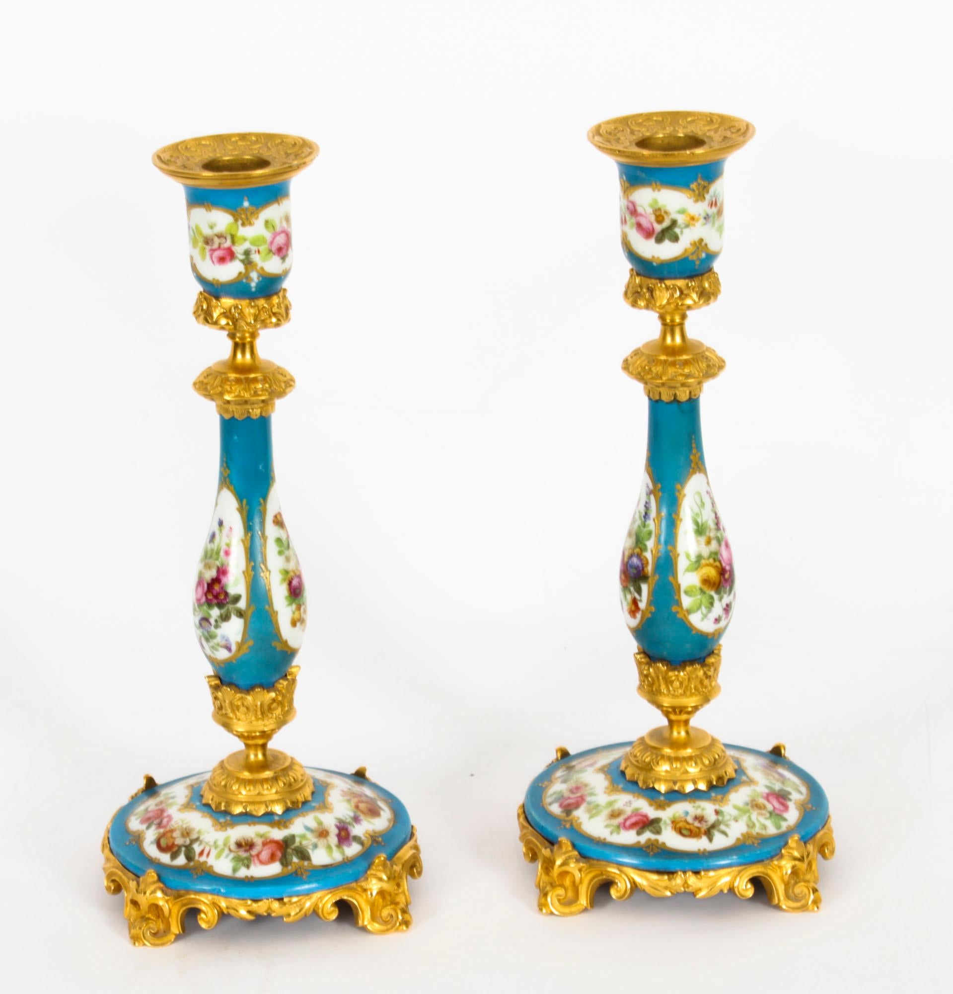 This is a delightful antique pair of French Sevres porcelain mounted ormolu candlesticks, circa 1880 in date.
 
The baluster shaped Sevres porcelain columns feature hand painted panels of summer flowers on a bleu celeste ground with gilt