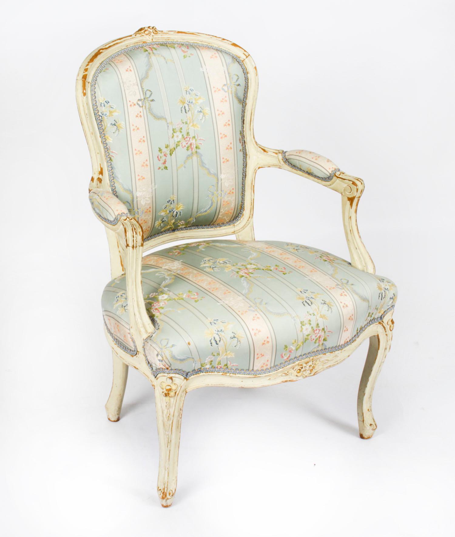 This is a beautiful antique pair of Louis Revival French shabby chic cream painted fauteuils, or open armchairs, late 19th century in date.
 
They each feature a flower carved crested toprail with acanthus clasped arm padded supports. They are