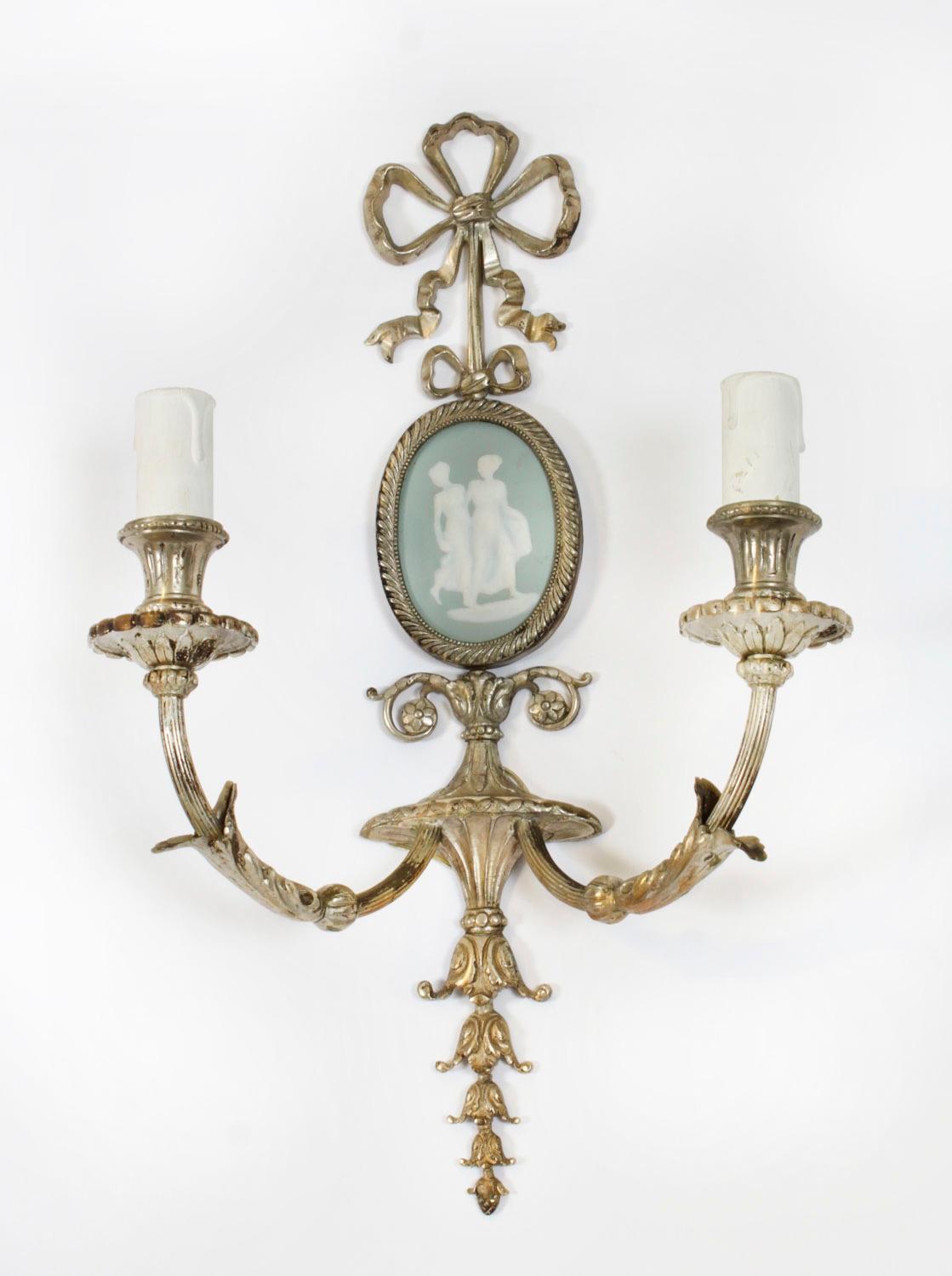 Il s'agit d'une superbe paire d'appliques anciennes en bronze doré et porcelaine à deux branches, datant d'environ 1900,

De forme classique élégante, avec une crête en ruban, des bras cannelés renversés avec un décor d'acanthes et des appliques
